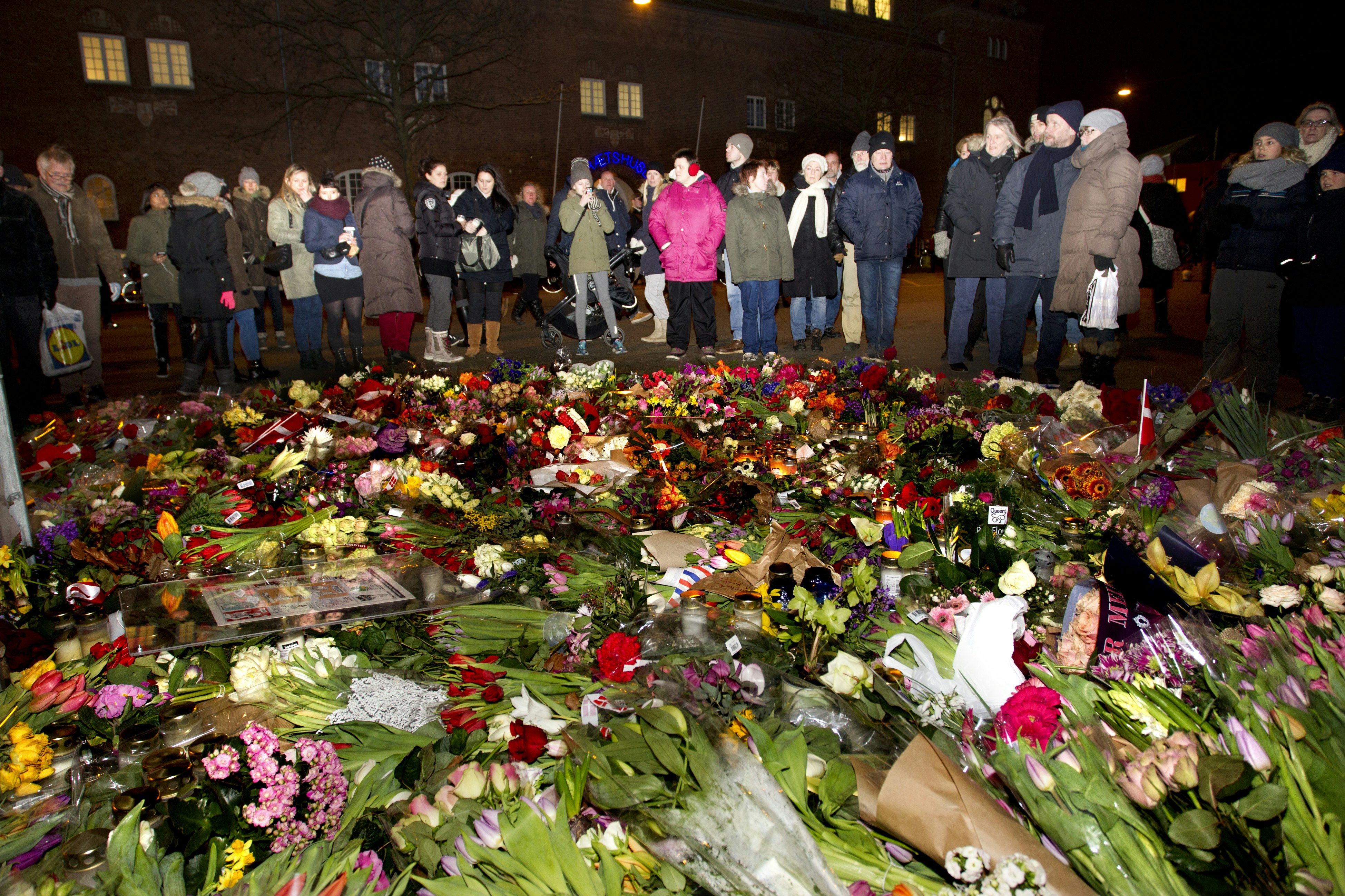 Fremmødte mennesker med blomster foran Krudttønden i København 