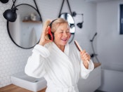 Kvinde synger i badeværelset og bruger hårbørsten som mikrofon