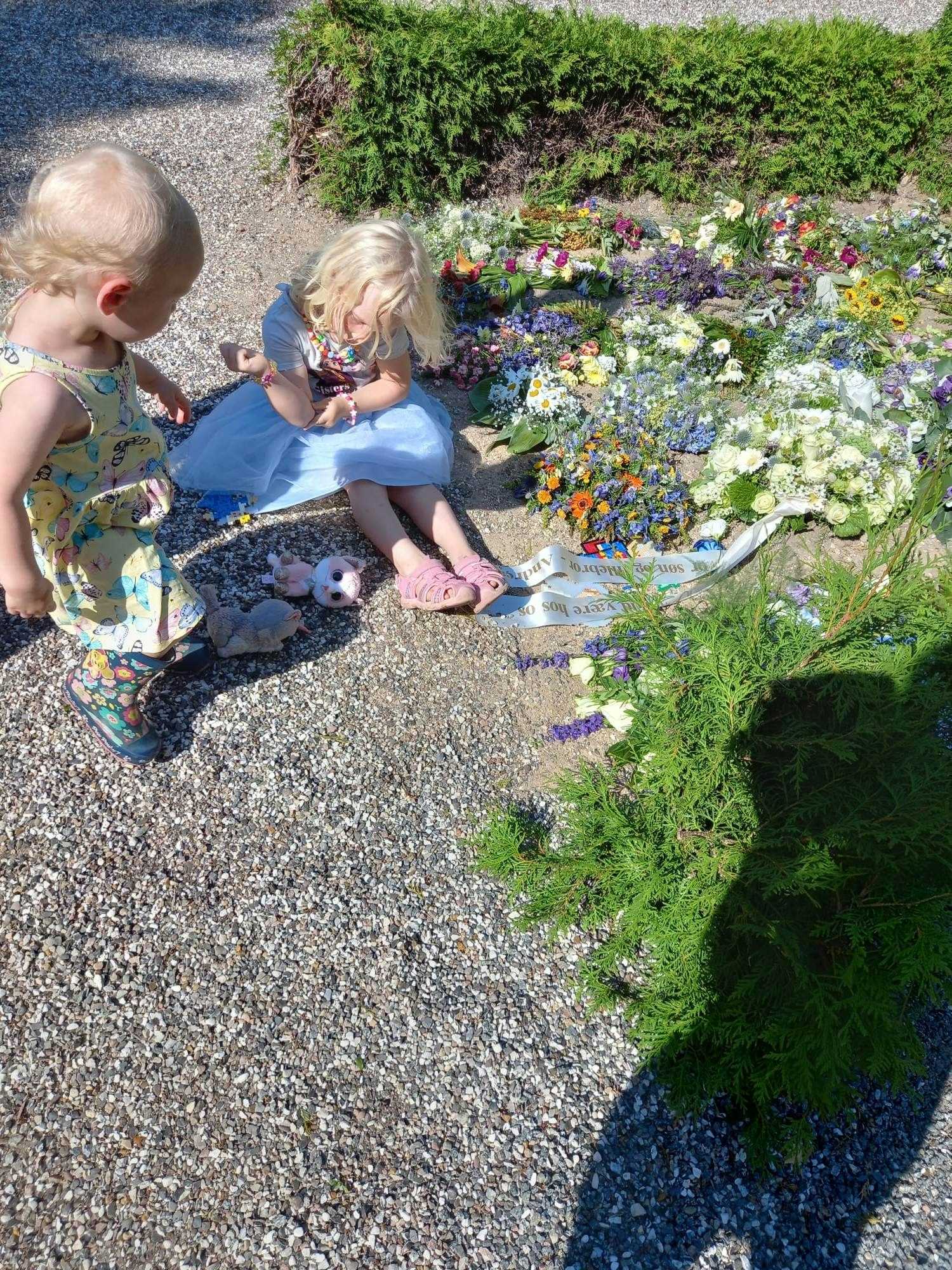 Dagmars to døtre besøger blomsterhavet efter Andreas' begravelse.
