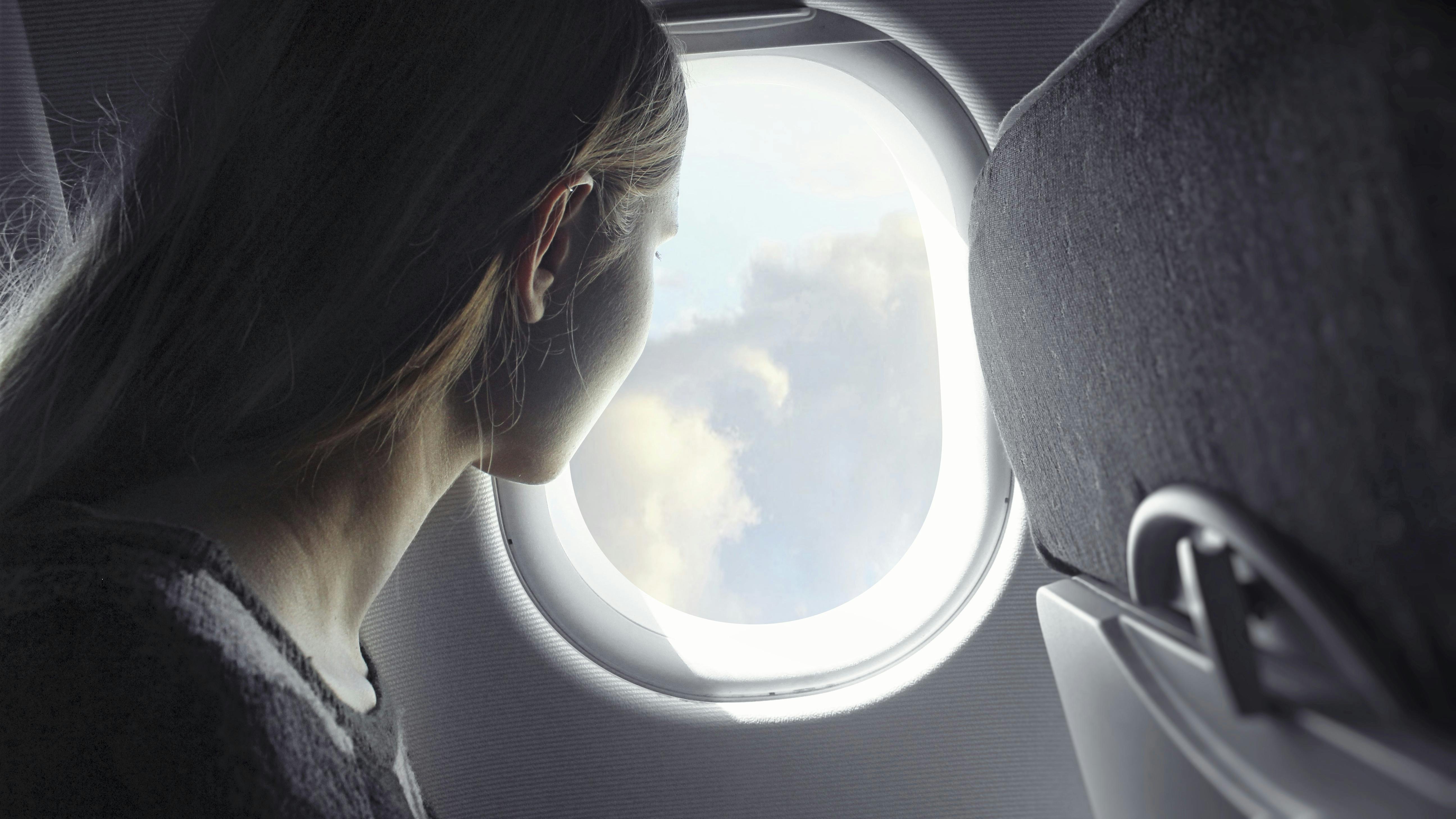 Kvinde kigger ud af et vindue i et fly