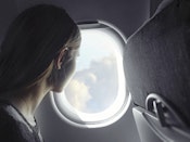 Kvinde kigger ud af et vindue i et fly