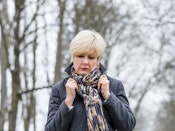 Kvinde med jakke går i skov