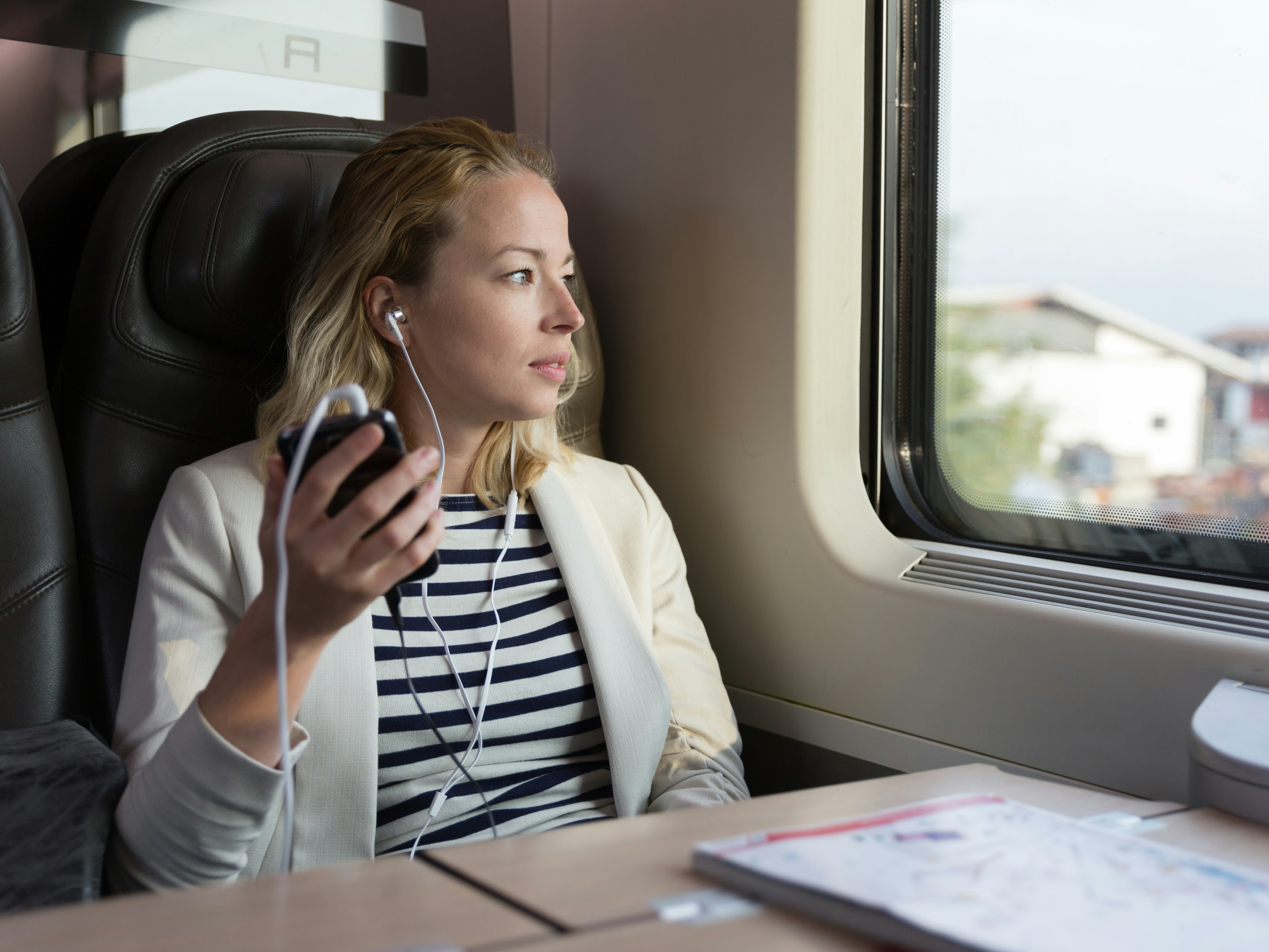 Kvinde i tog lytter til podcast