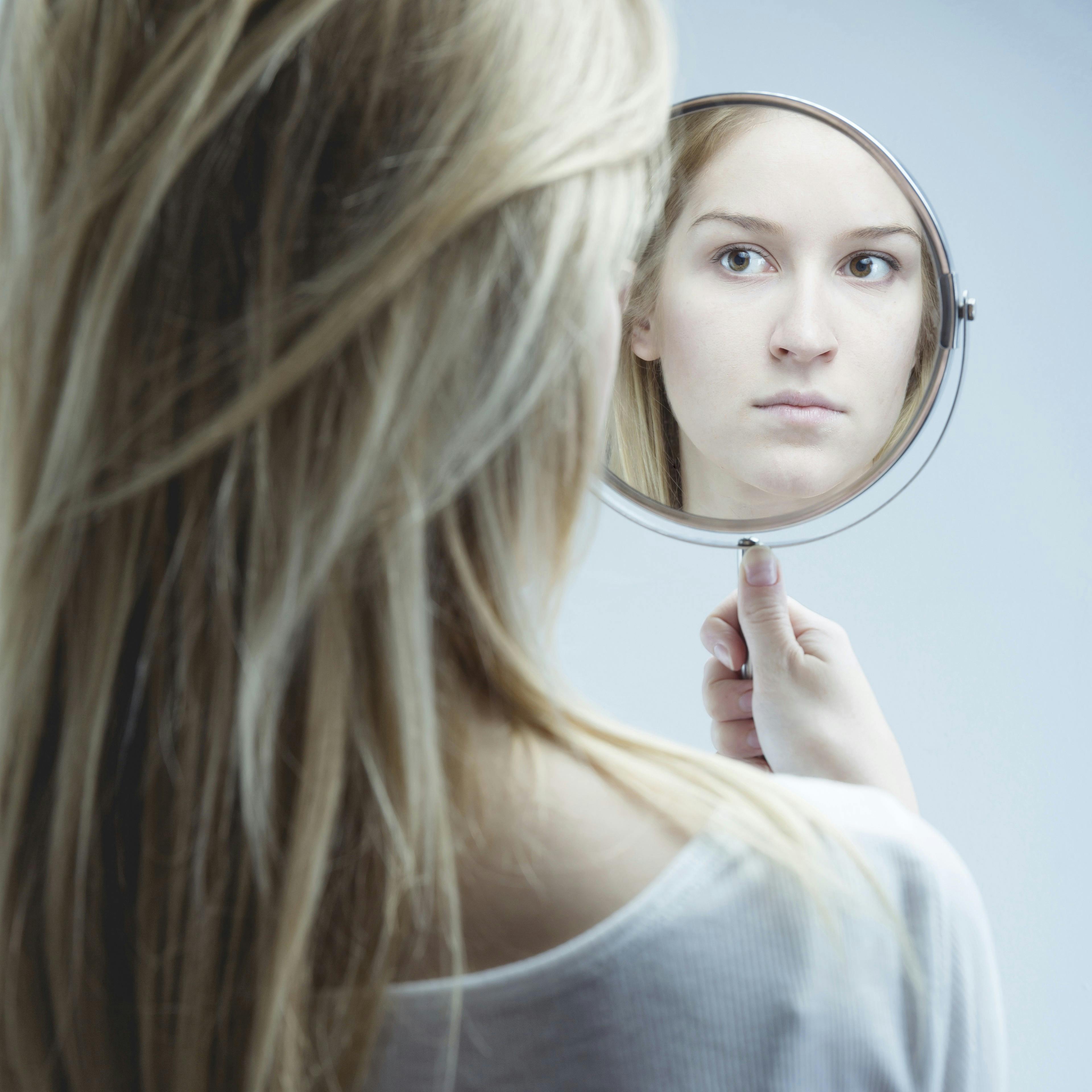 Kvinde kigger sig selv i spejlet