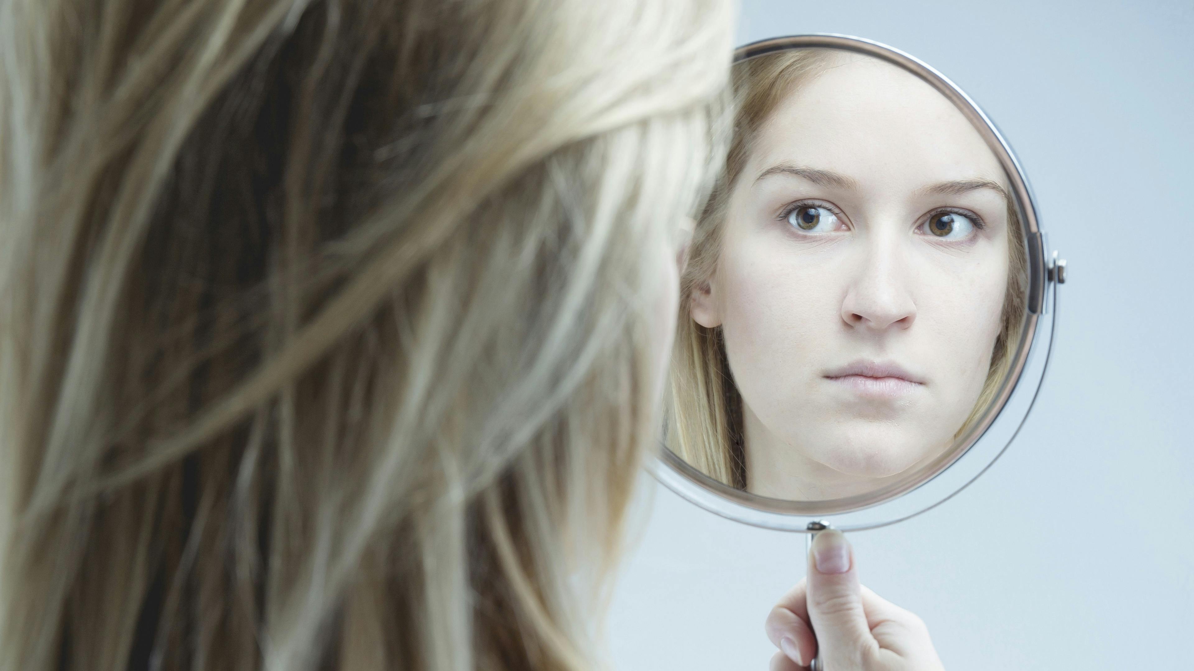 Kvinde kigger sig selv i spejlet