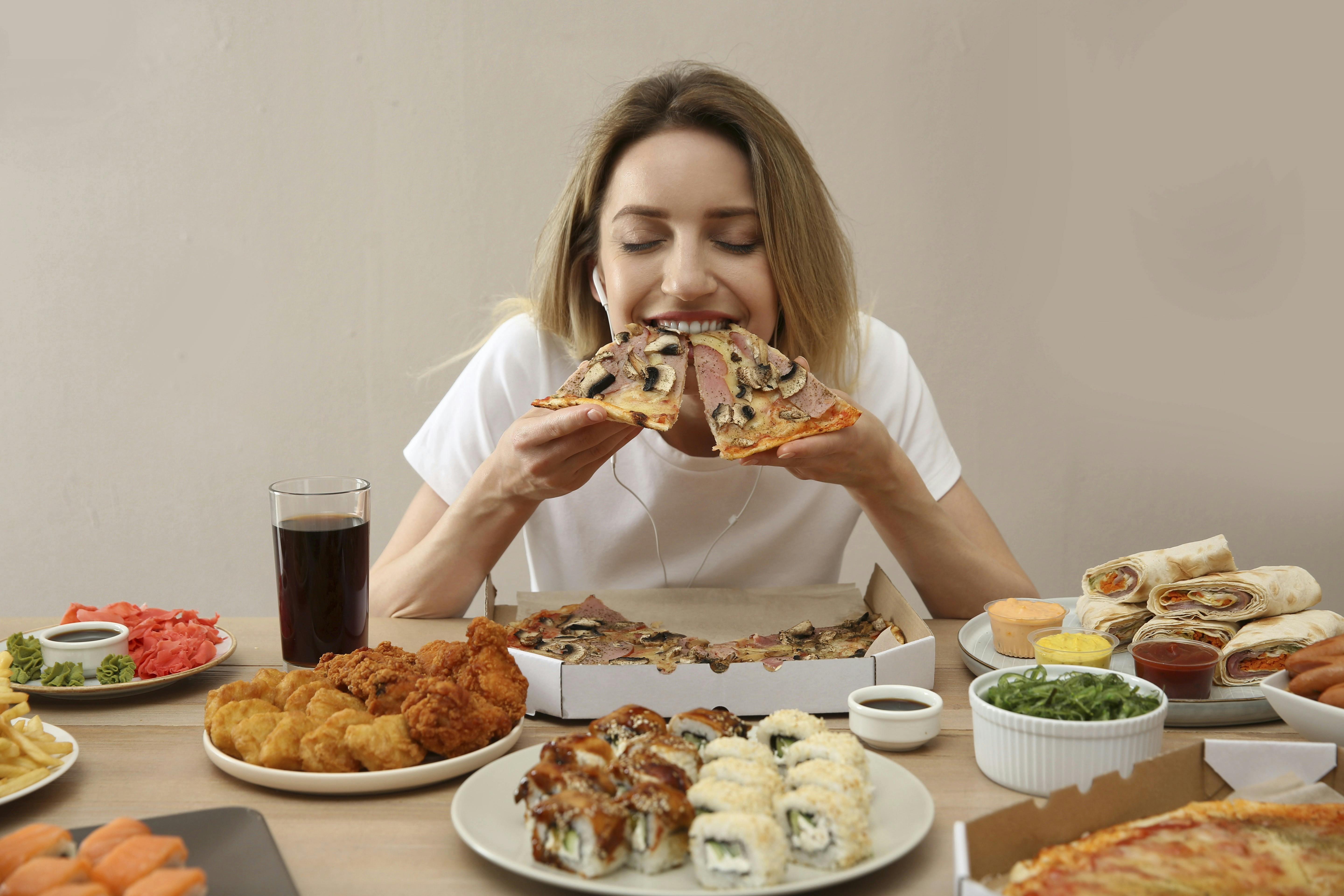 Et bord fyldt med mad, som en kvinde spiser
