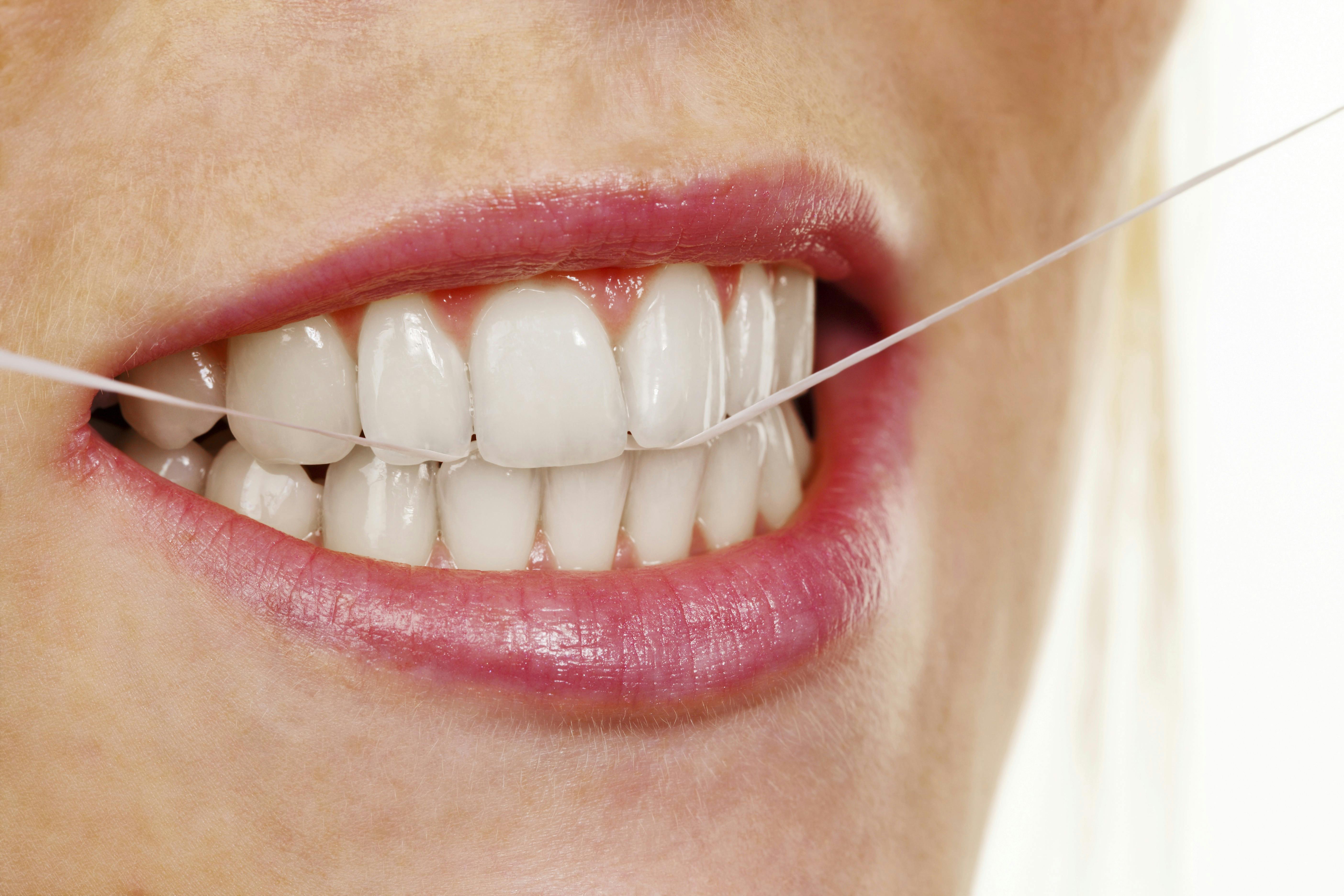 Kvinde bruger tandtråd