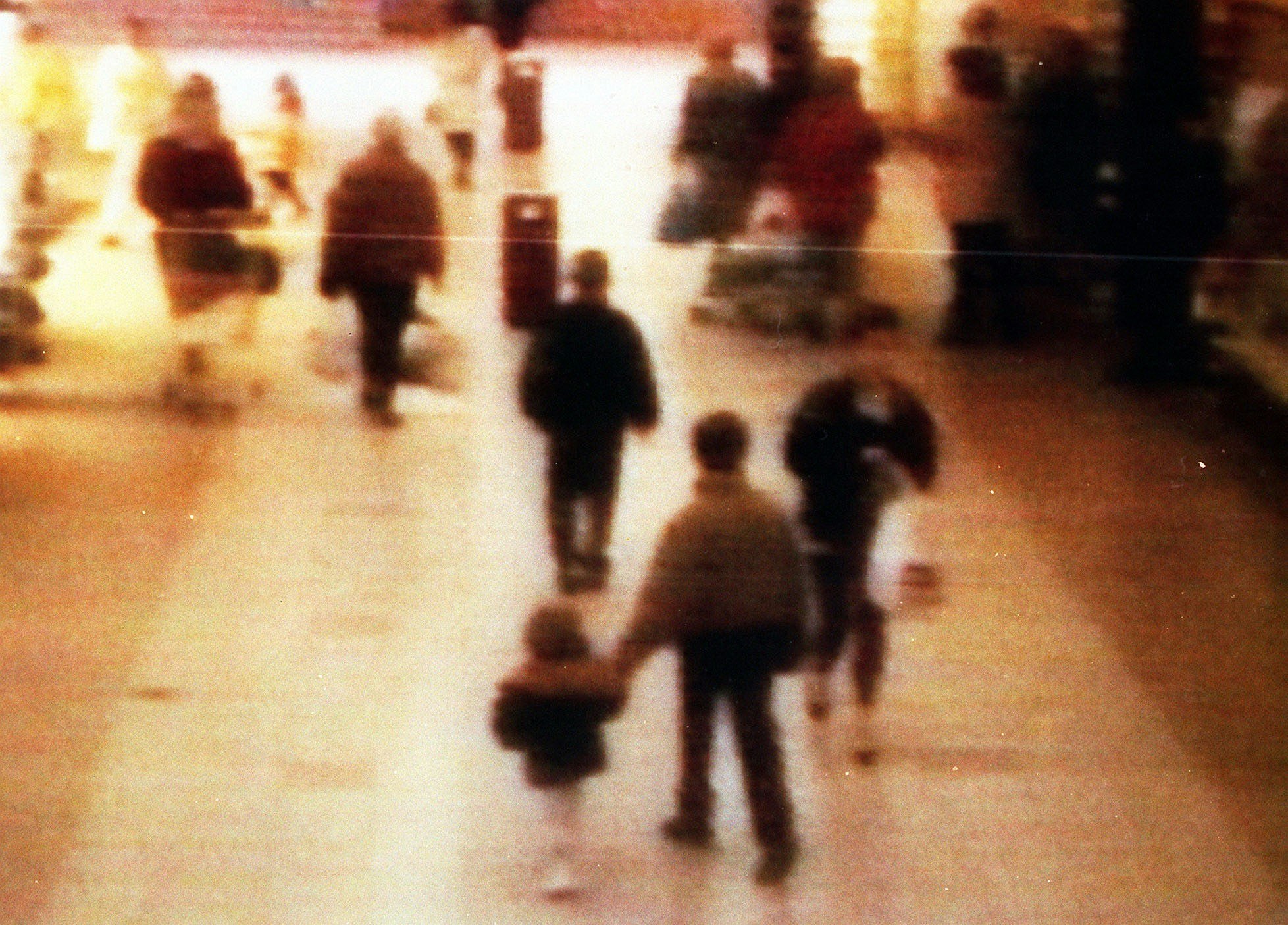 2-årige James Bulger blive ført væk af to drenge.