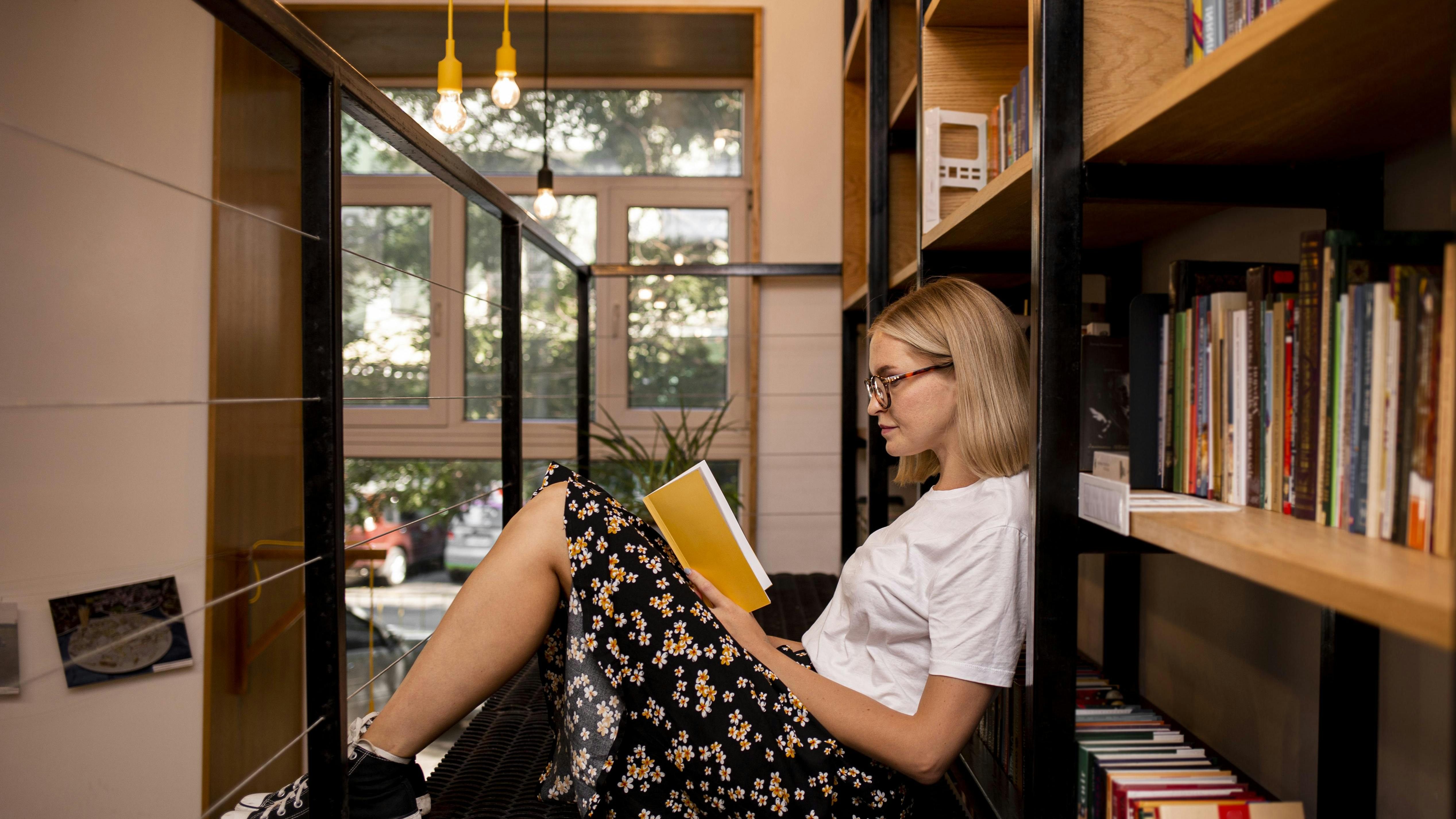 Kvinde læser en bog på et bibliotek