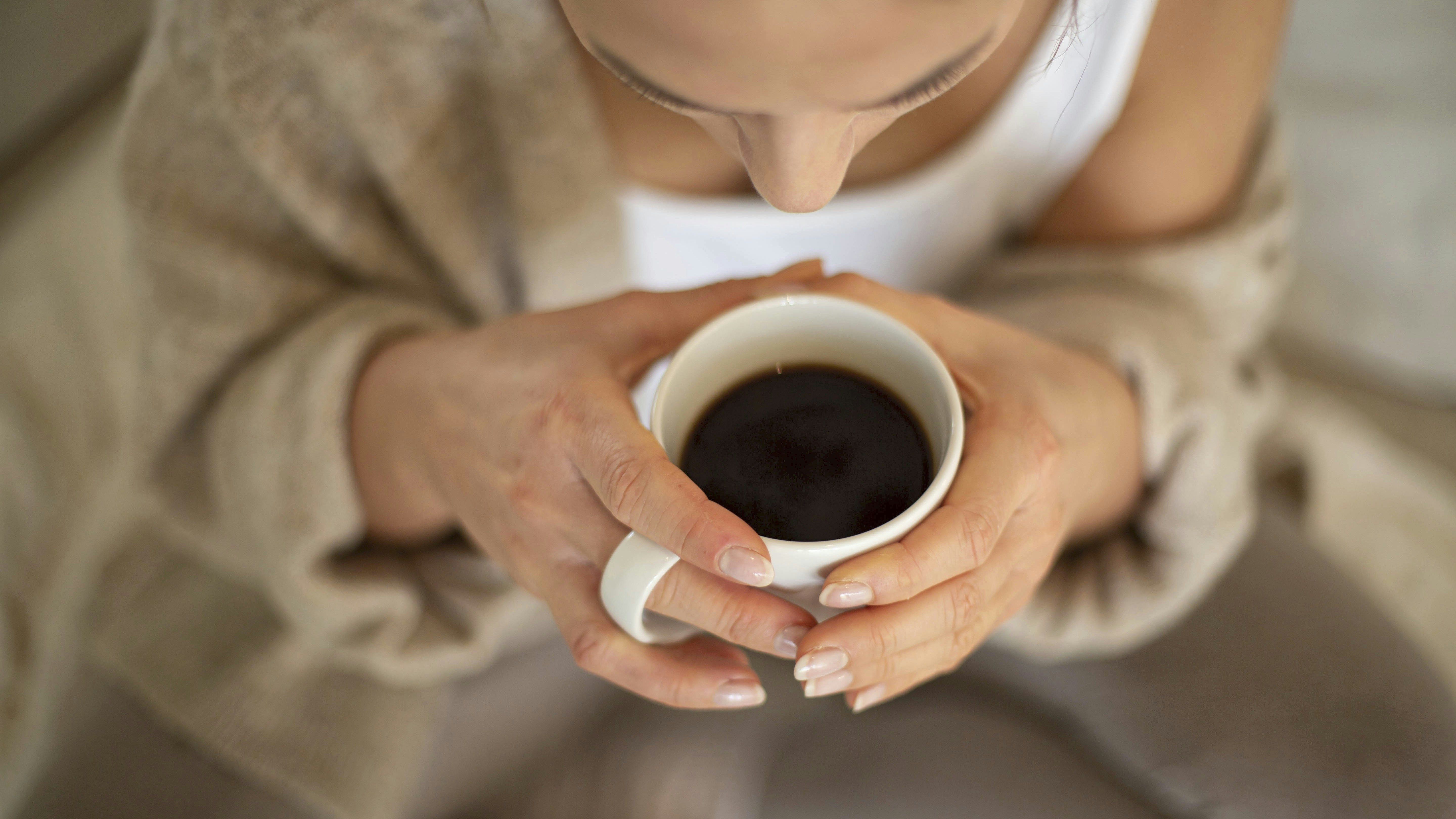 Kvinde holder en kop med kaffe