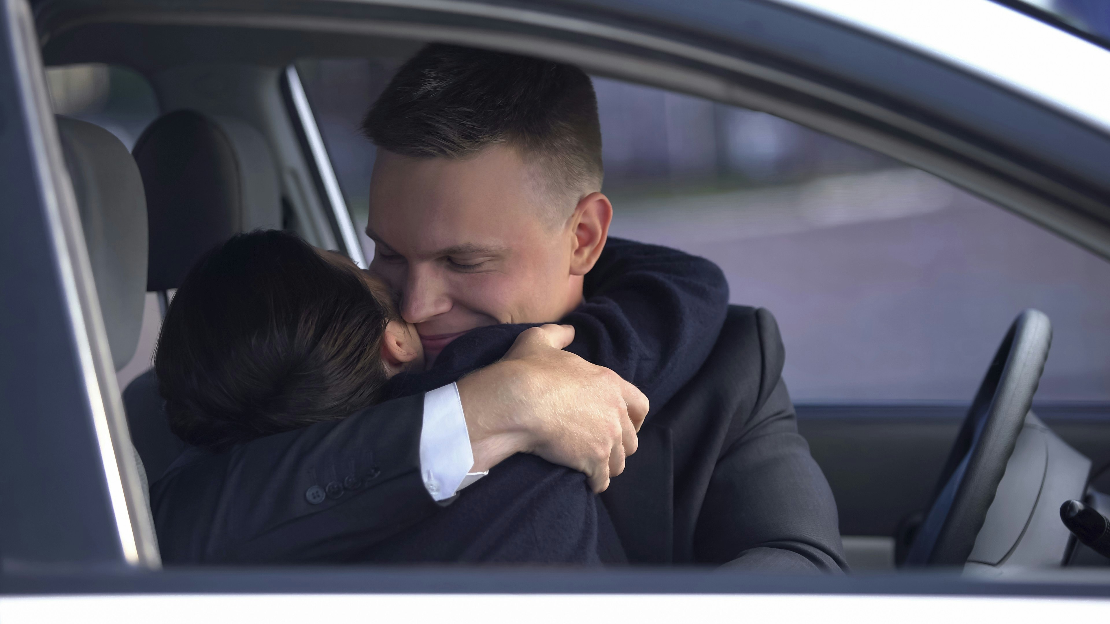 Mand og kvinde omfavner hinanden i bil