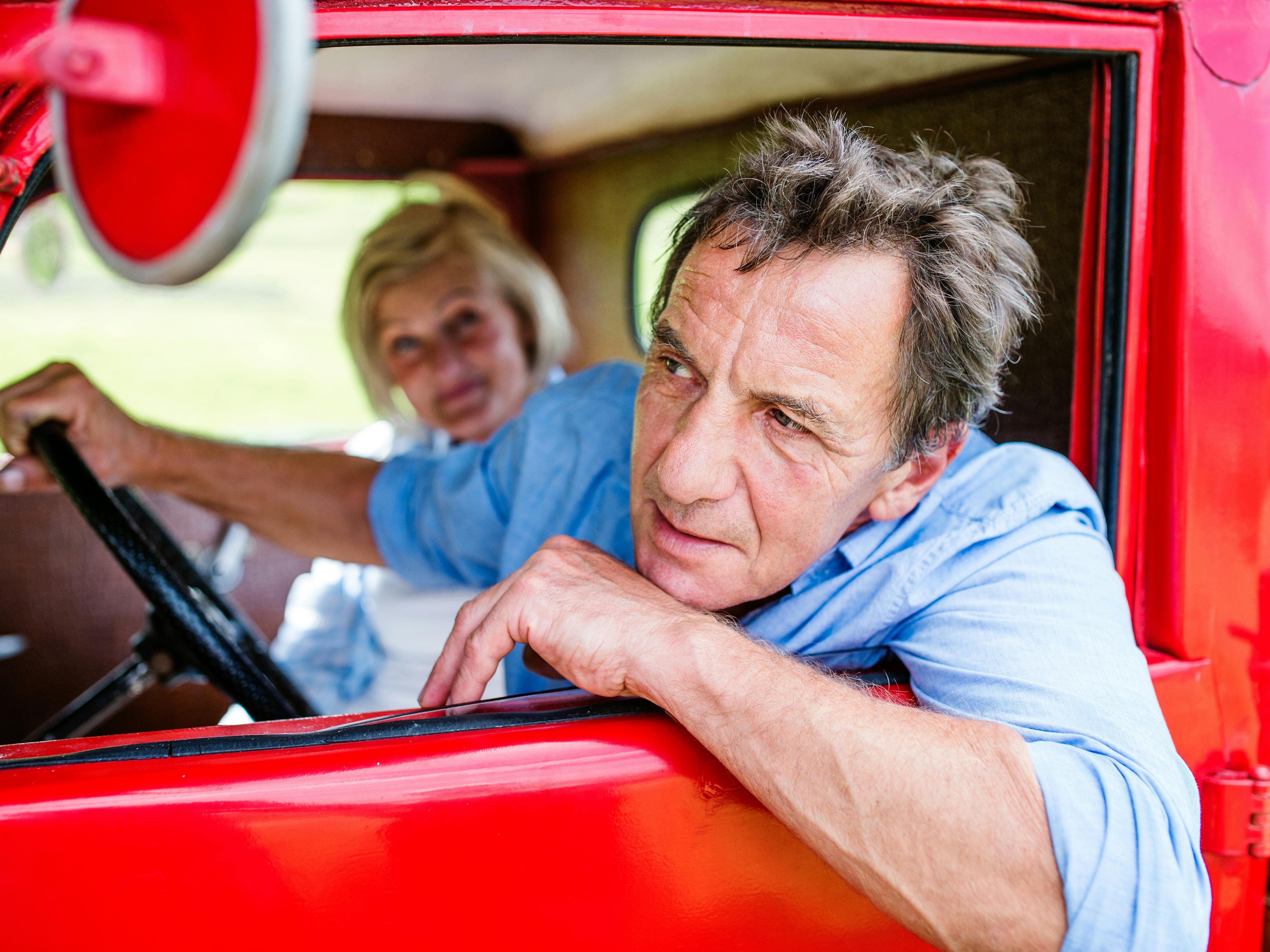 Midaldrende par kører i en gammel bil