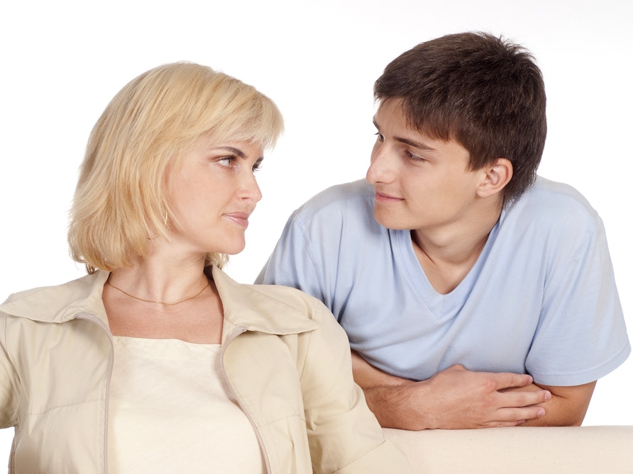 Midaldrende kvinde ser skeptisk på sin unge søn.