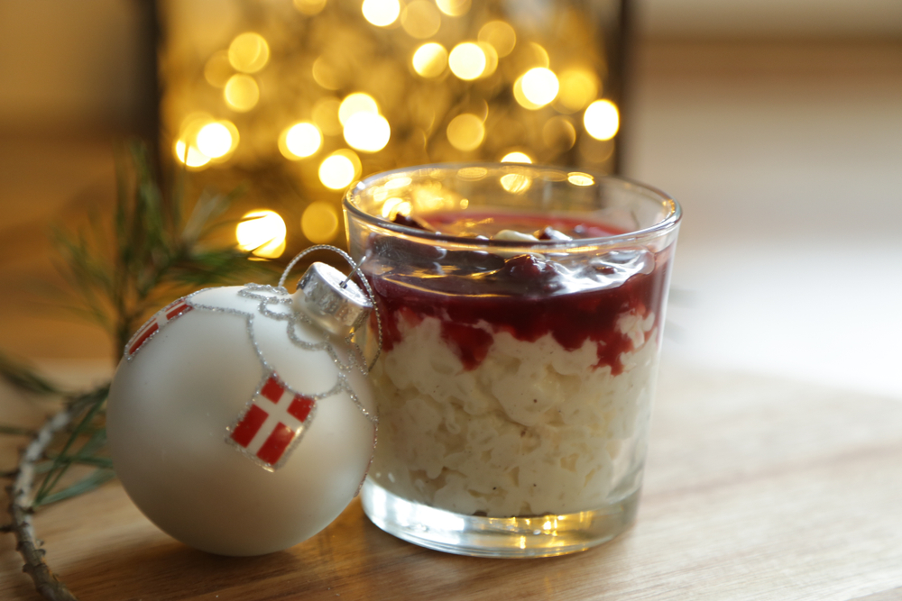 Glas med en portion risalamande med en julekugle ved siden af.