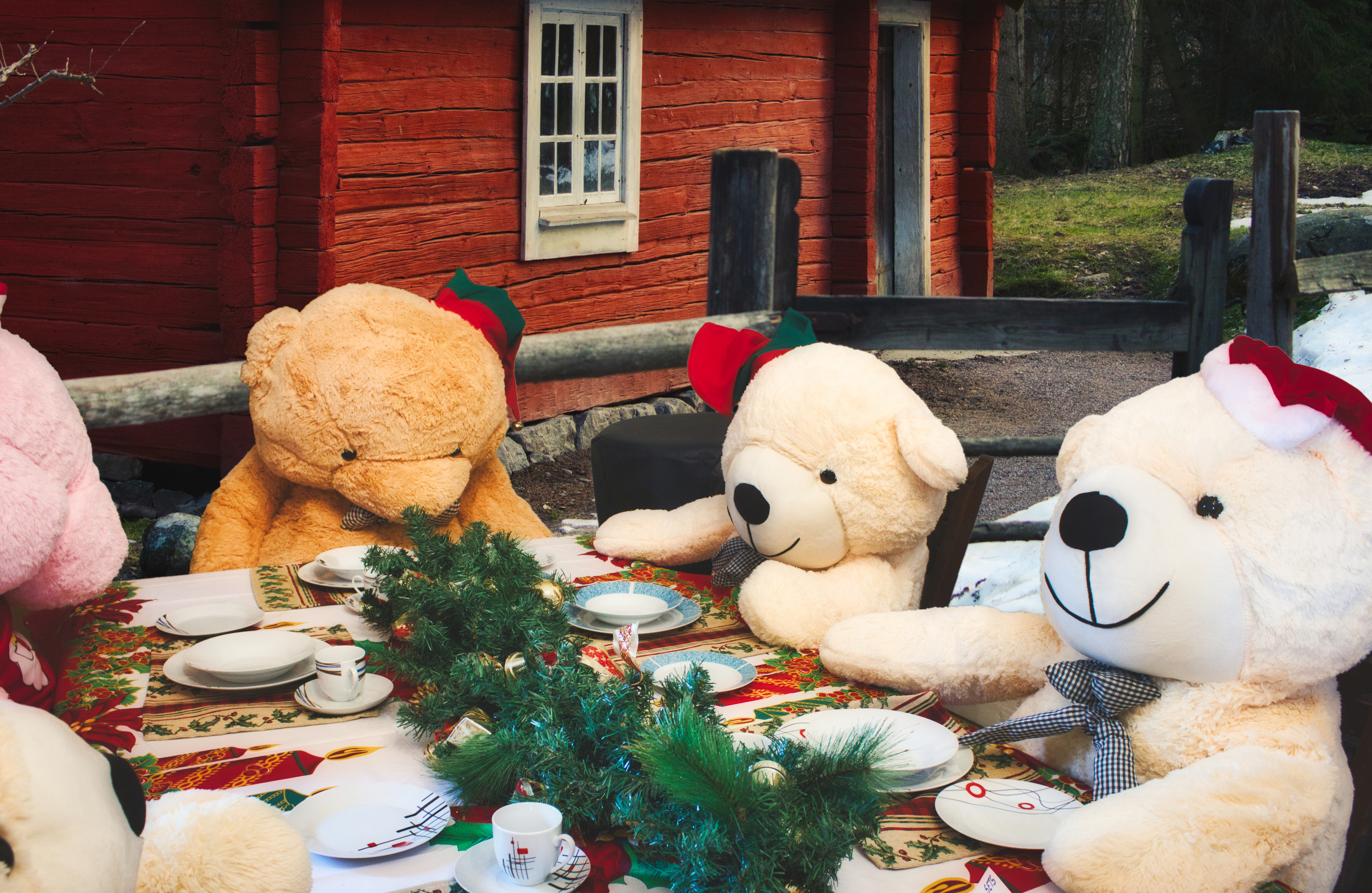 Fire bamser sidder omkring et flot dækket julebord