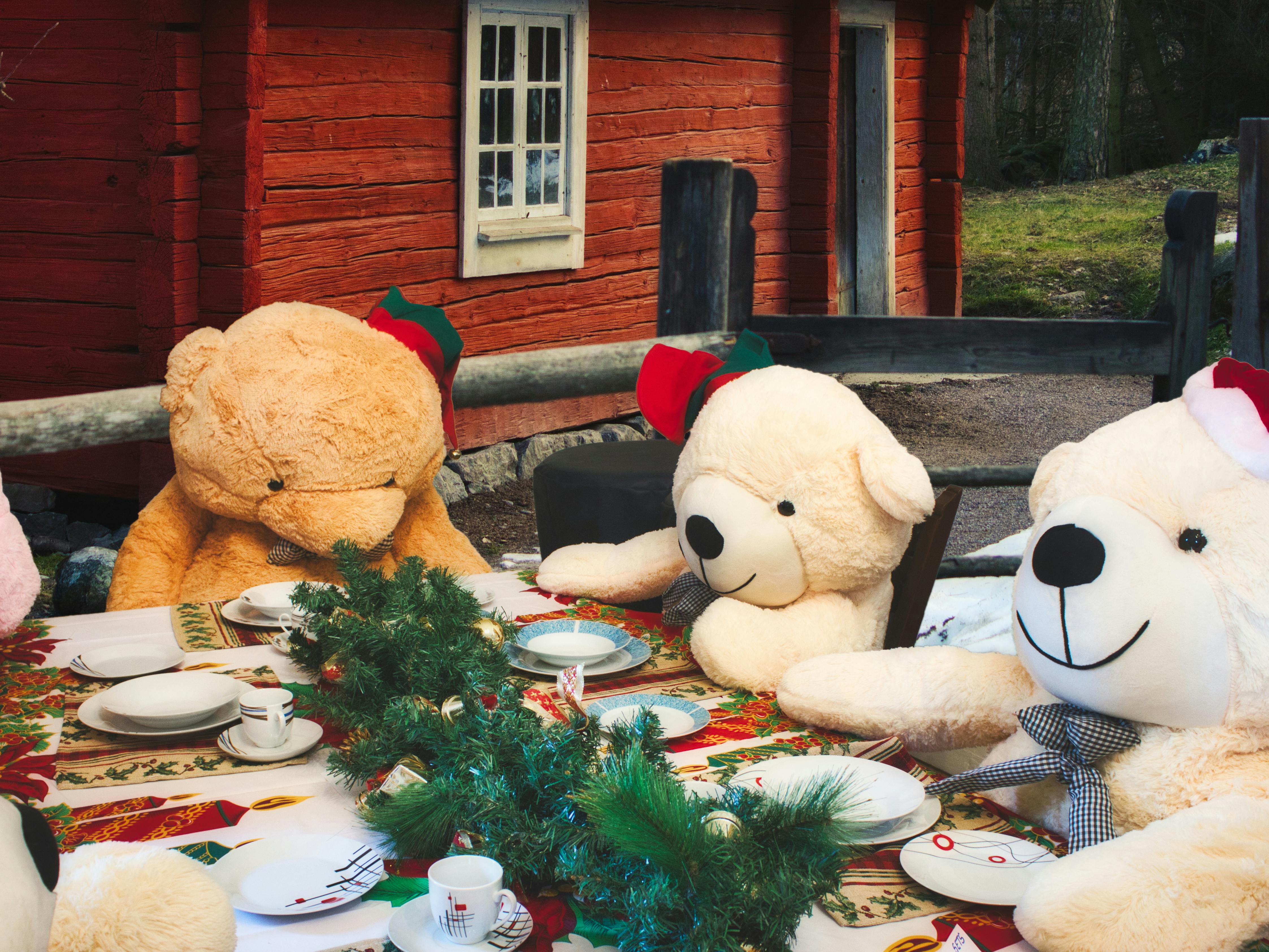 Fire bamser sidder omkring et flot dækket julebord