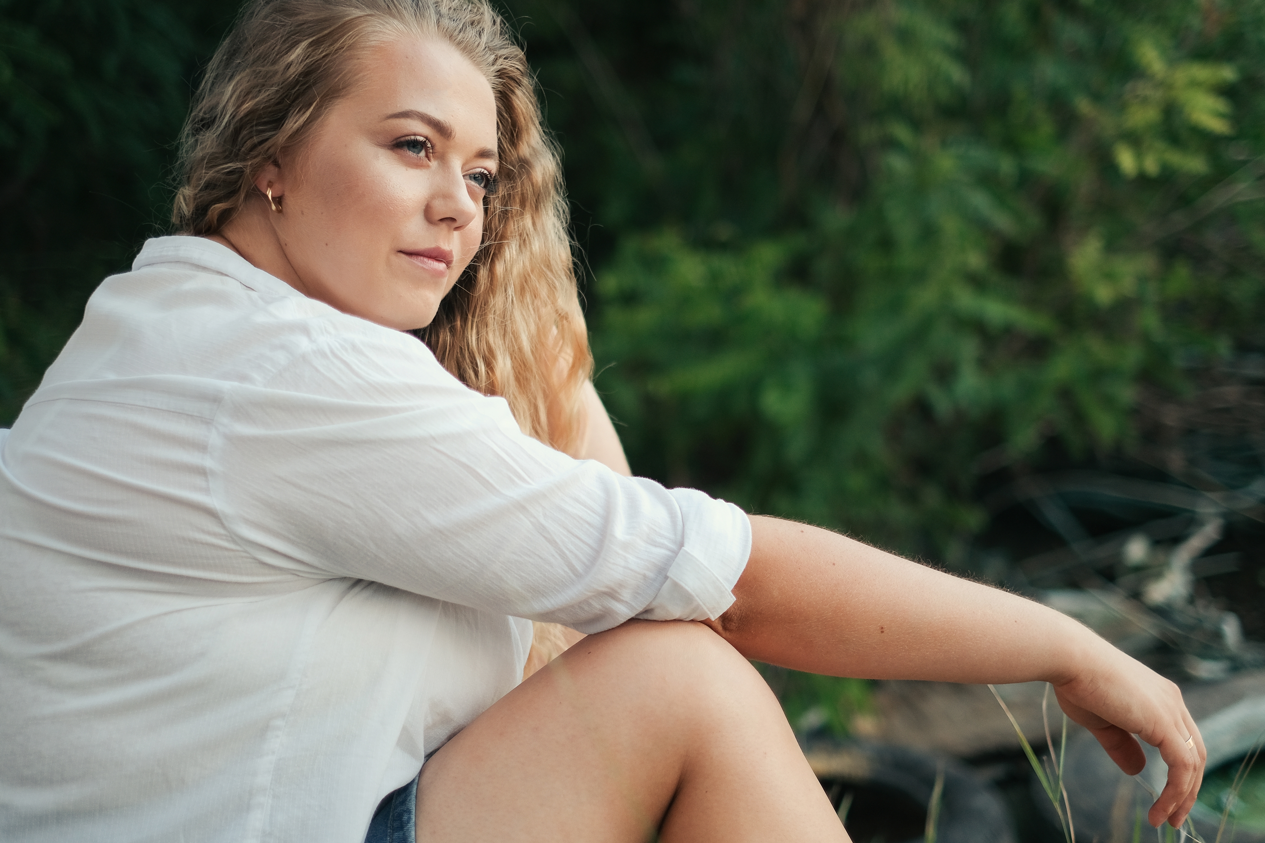 Ung kvinde med stor barm sidder og ser tænksom ud