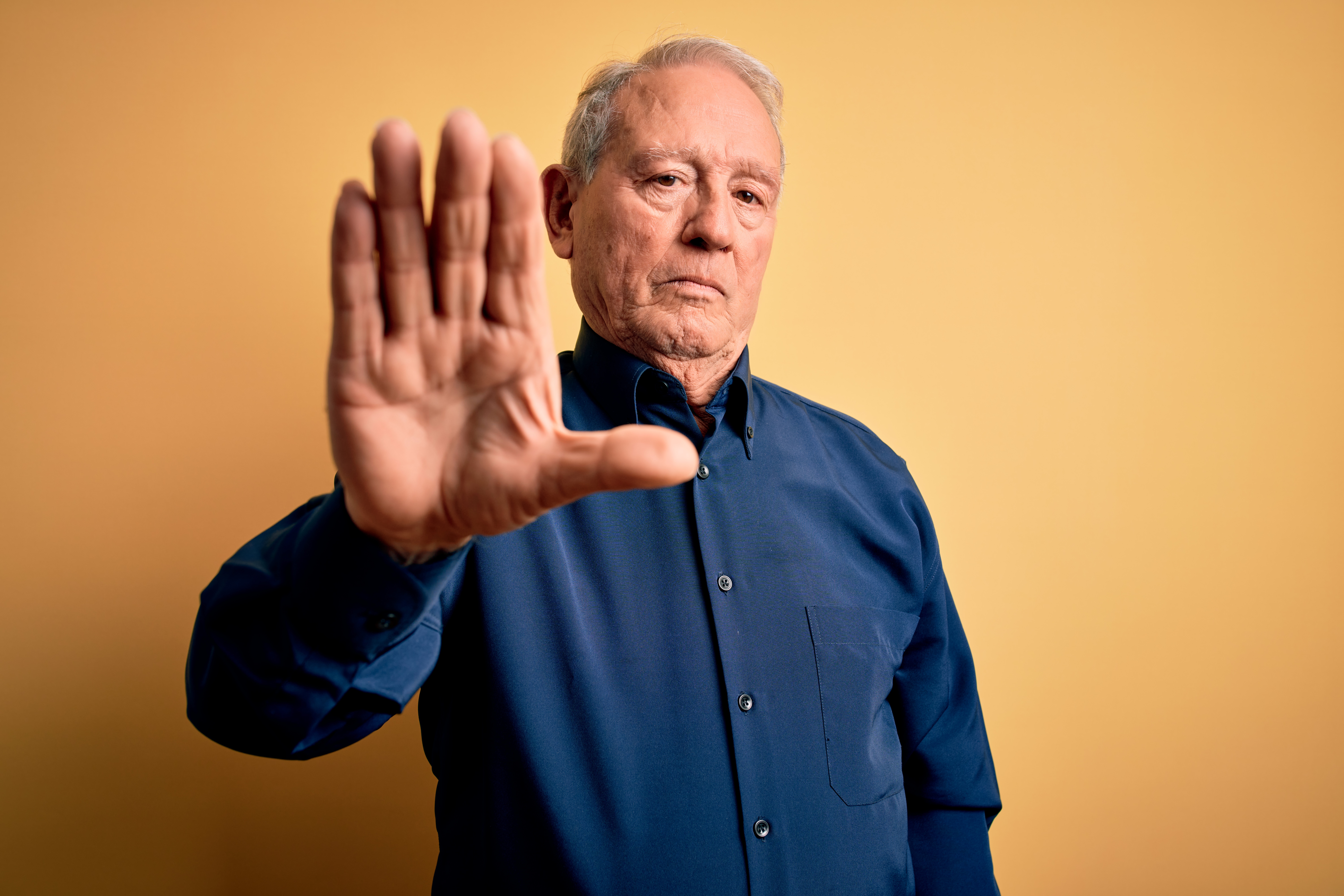 Midaldrende mand holder en afvisende hånd op foran sig