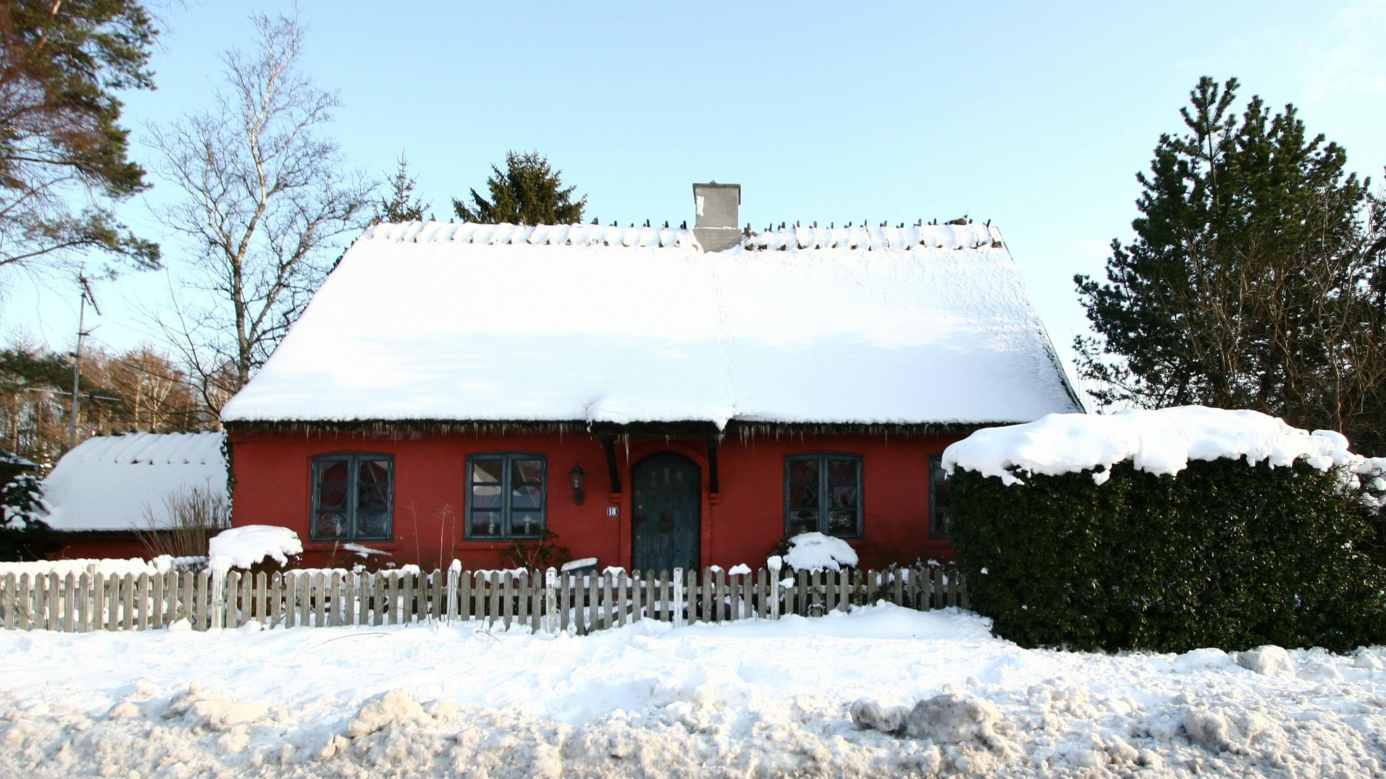 Gammel gård dækket af sne