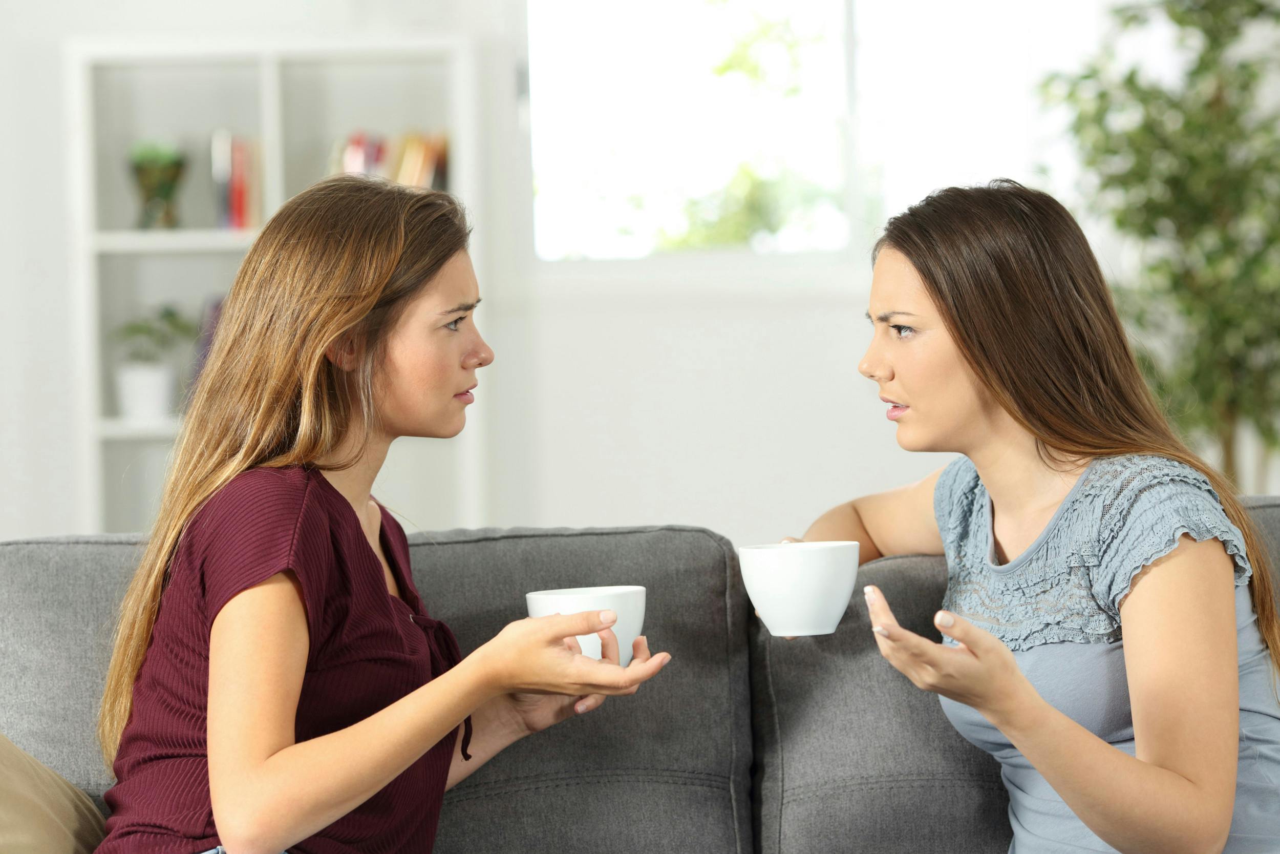 To veninder sidder i sofa og diskuterer.