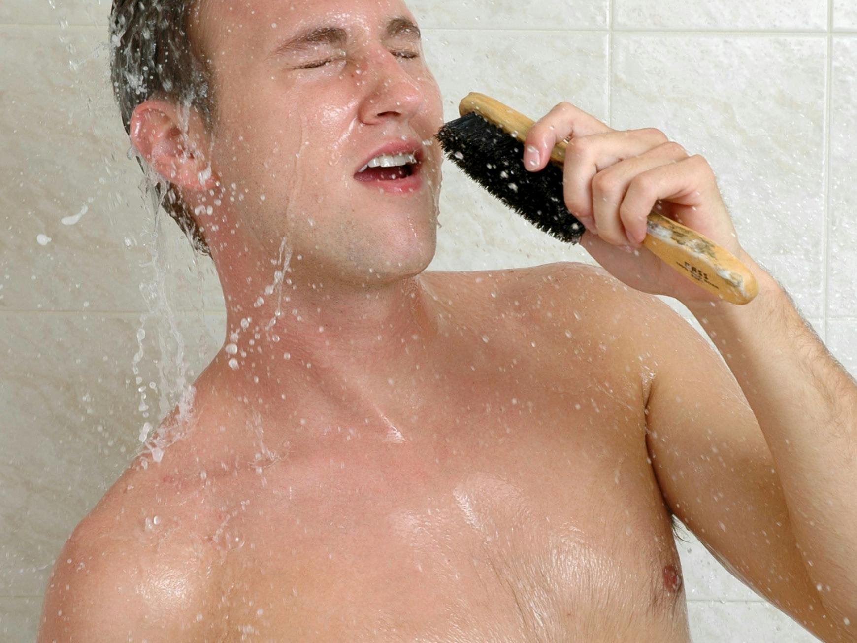 En ung mand synger i brusebadet