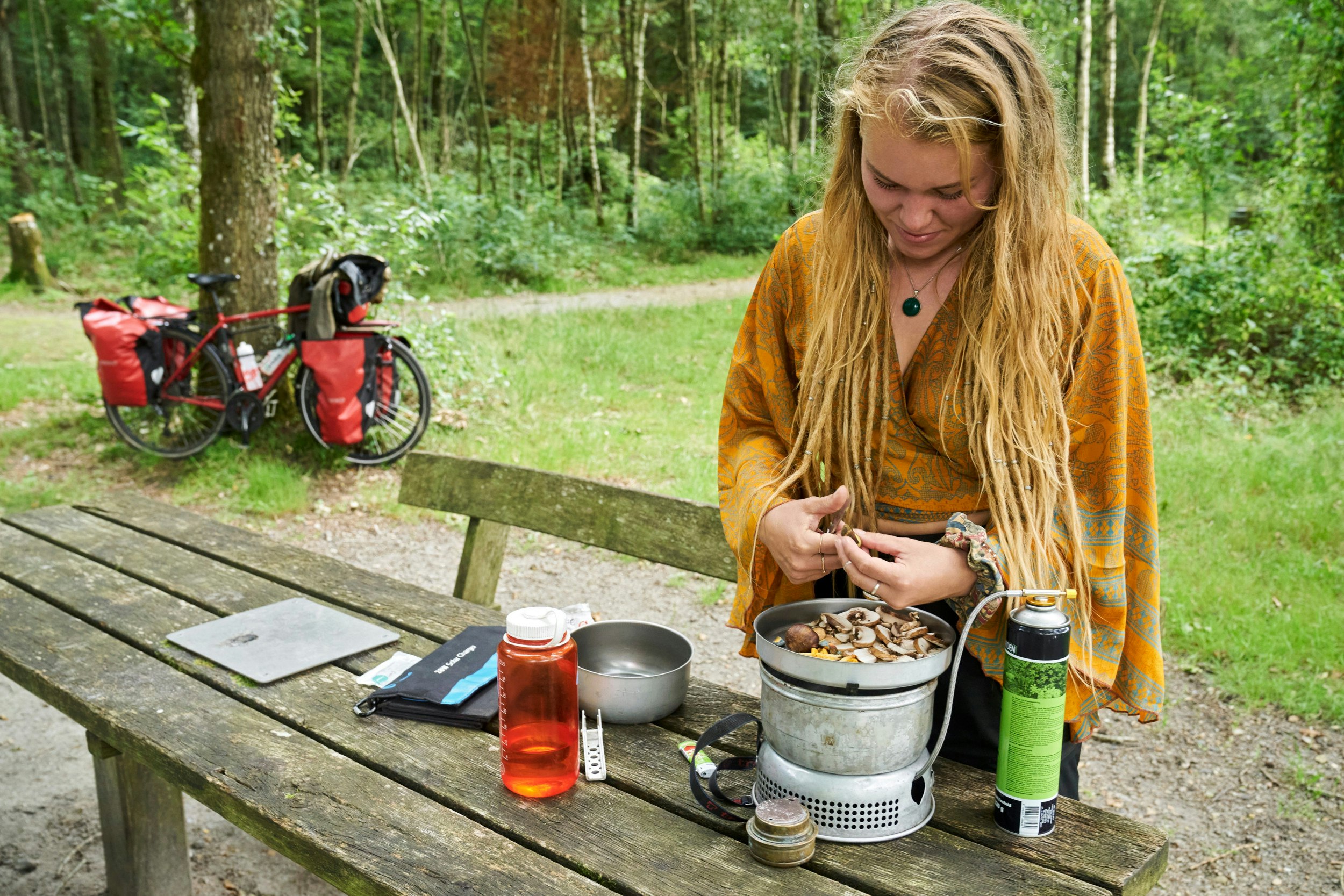 Dagens frokost tilberedes på et letvægtskogesæt med gasbrænder. Bag den røde vandflaske ses Anna-Carolines transportable solceller, som oplader hendes telefon.