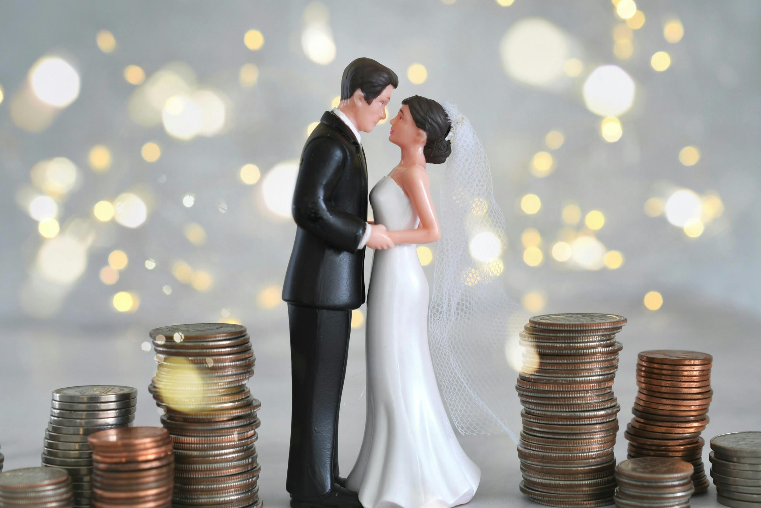 Figur af brudepar står mellem stakke af mønter
