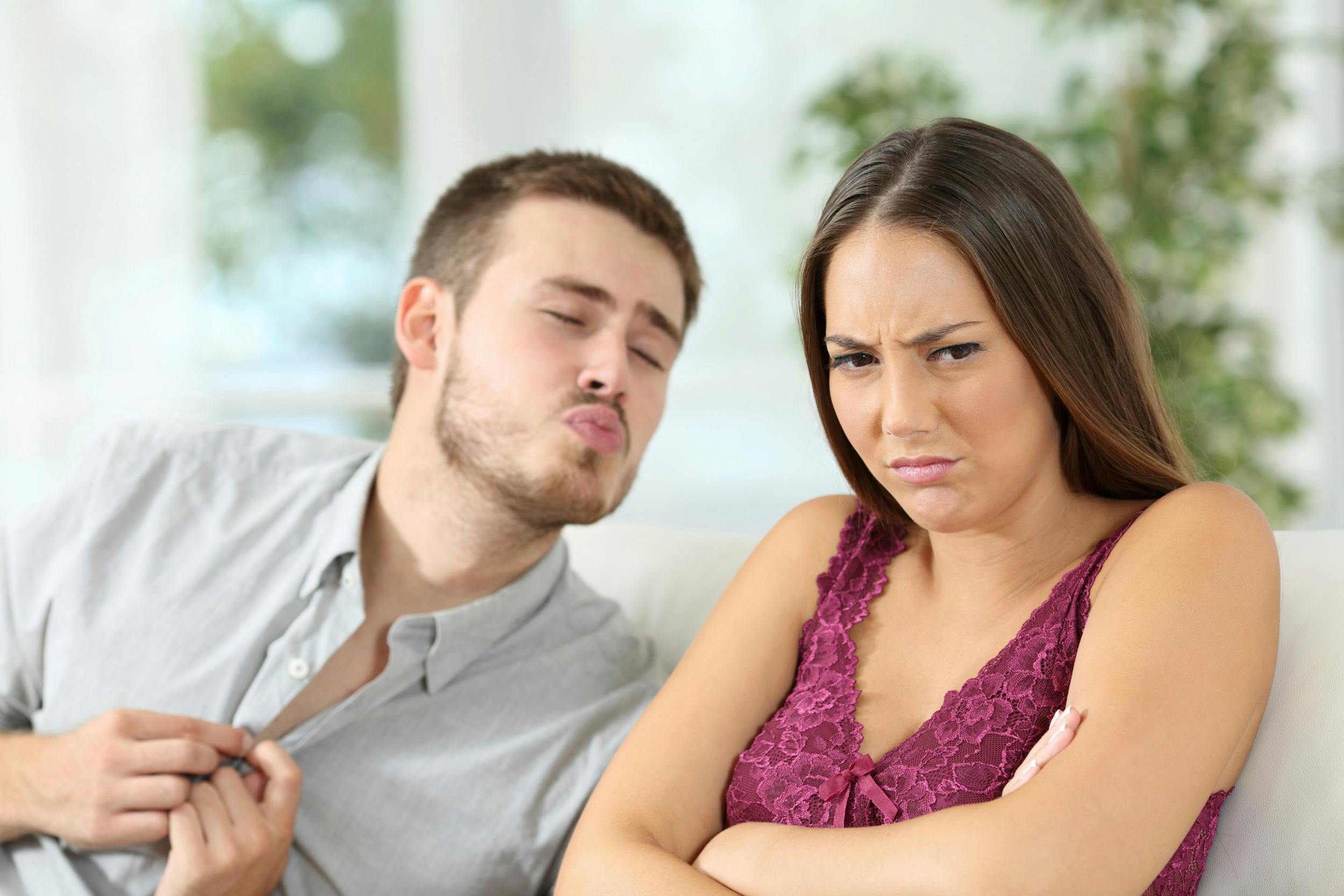 Mand sender kyssemund mod sin kæreste, der ser sur og trist ud