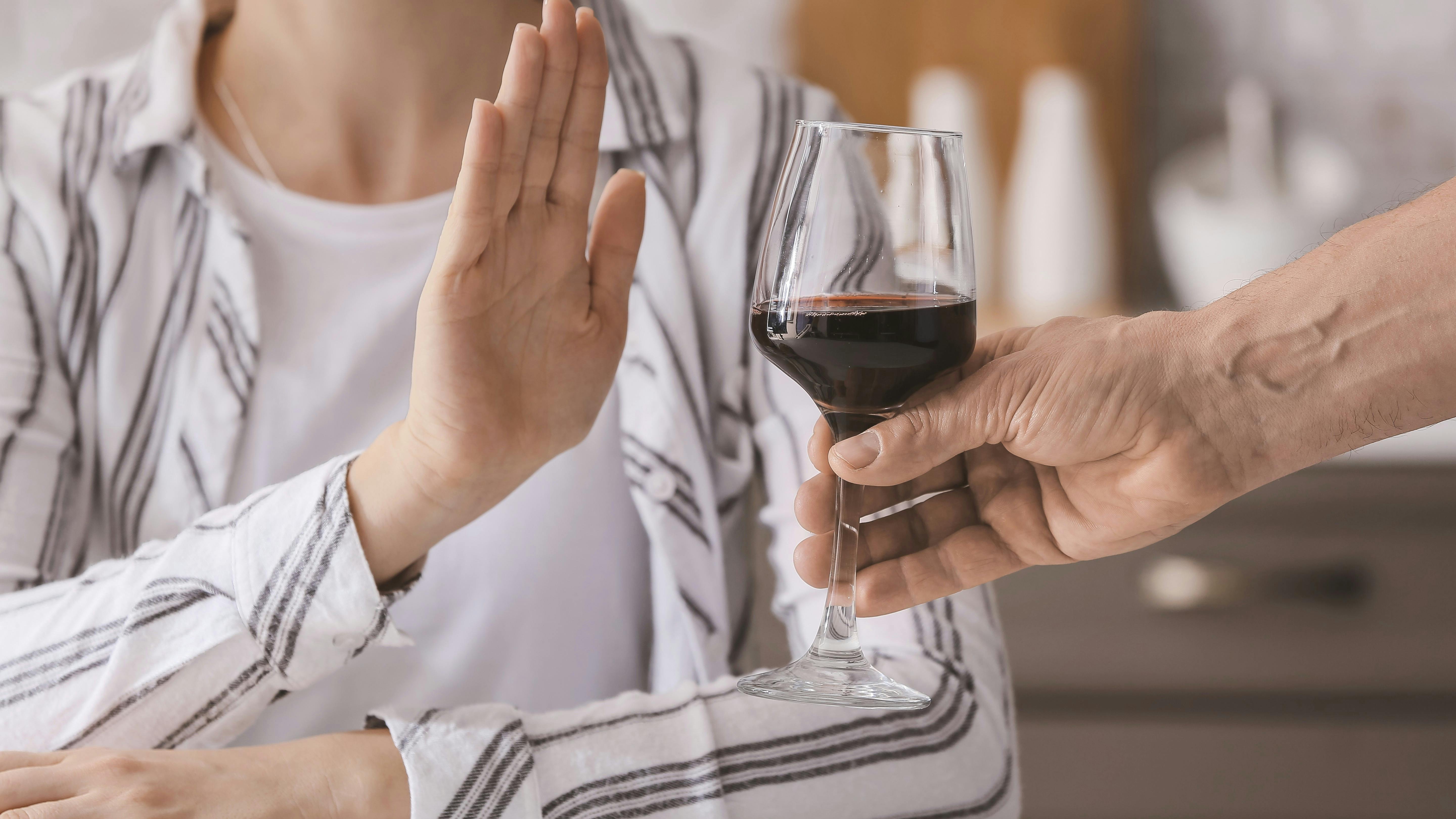 Kvinde takker nej til et glas rødvin
