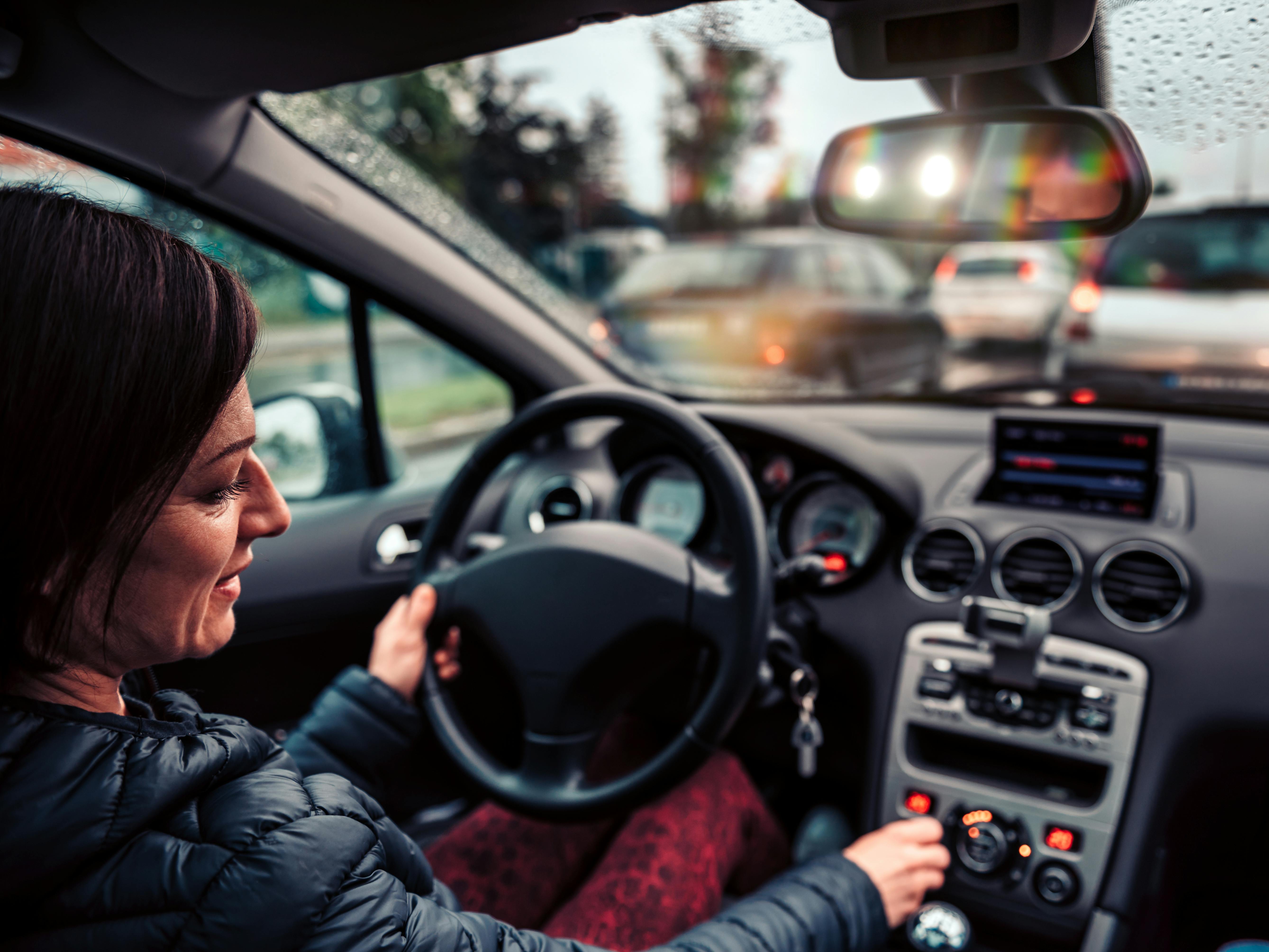Kvinde skruer på radioen i sin bil