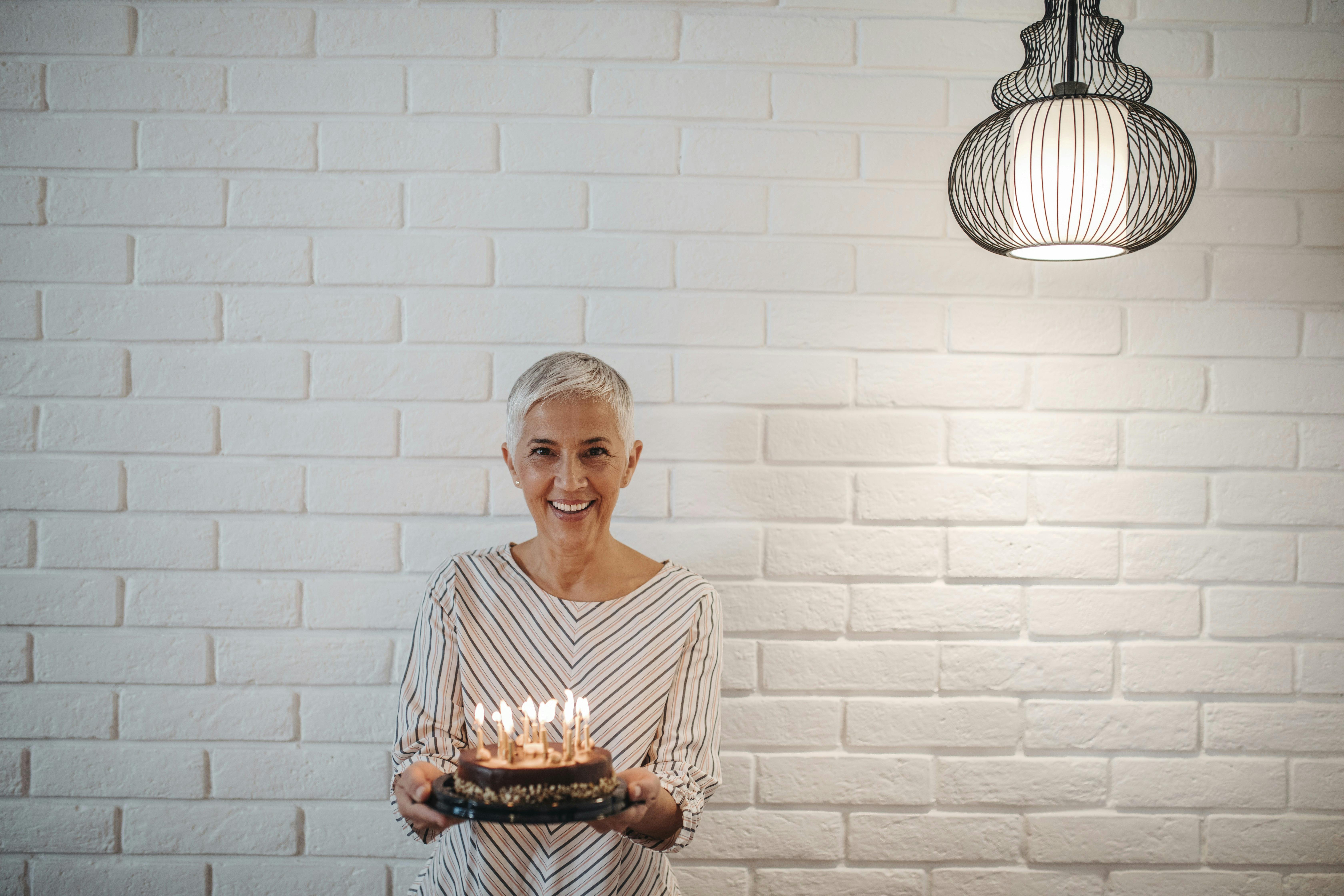 Kvinde står med en fødselsdagskage