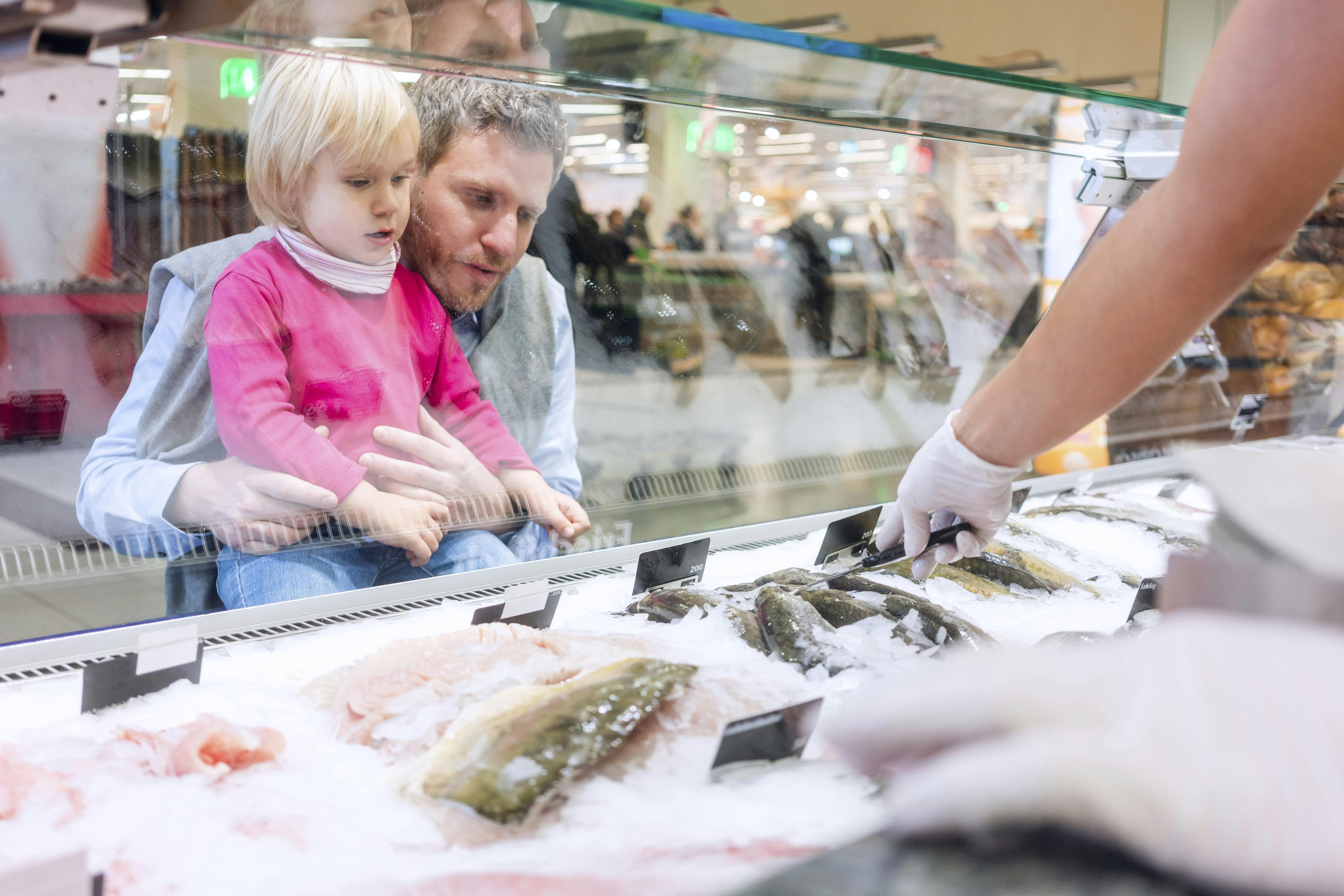 Familie køber fisk i et supermarked