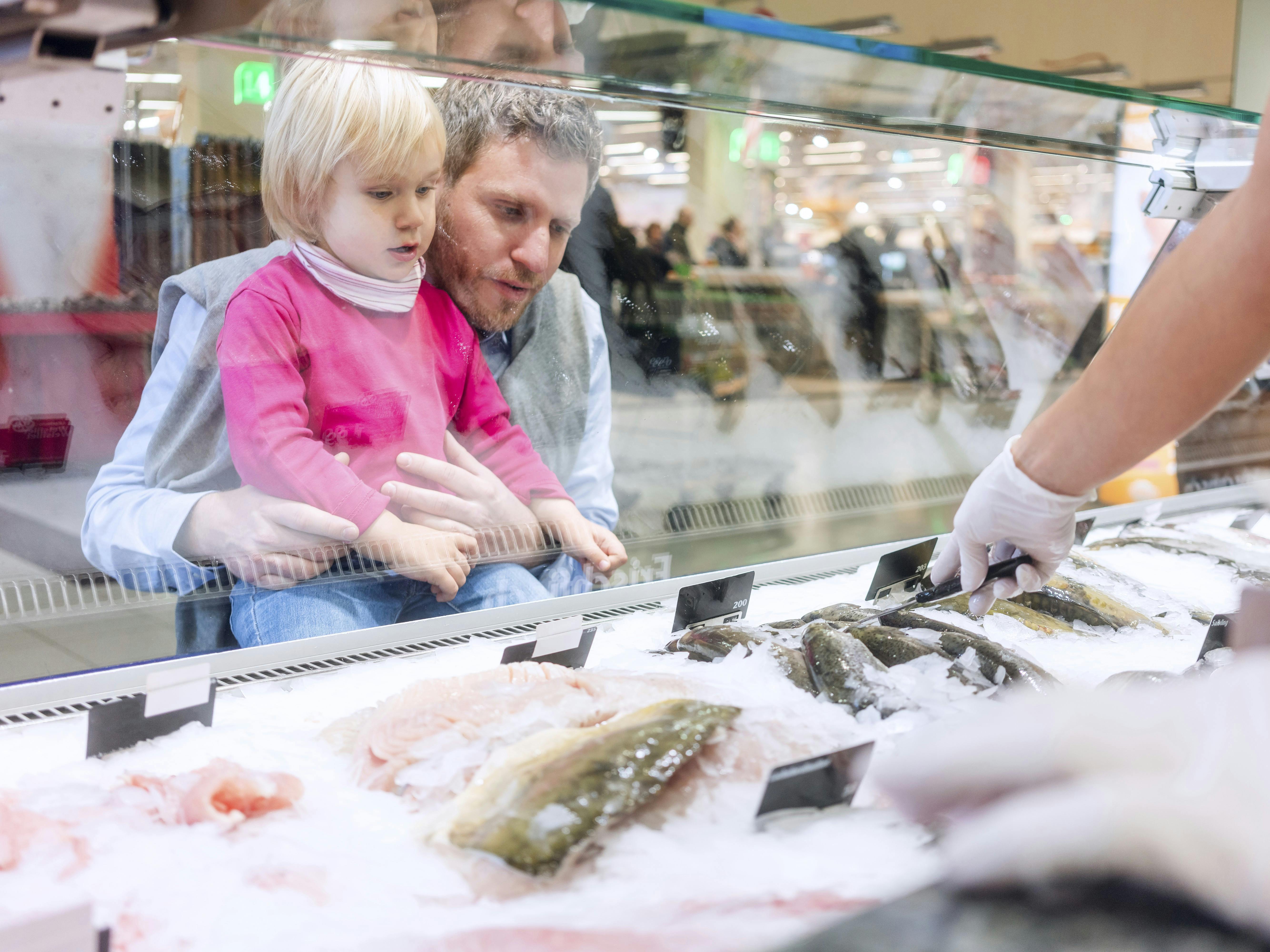 Familie køber fisk i et supermarked