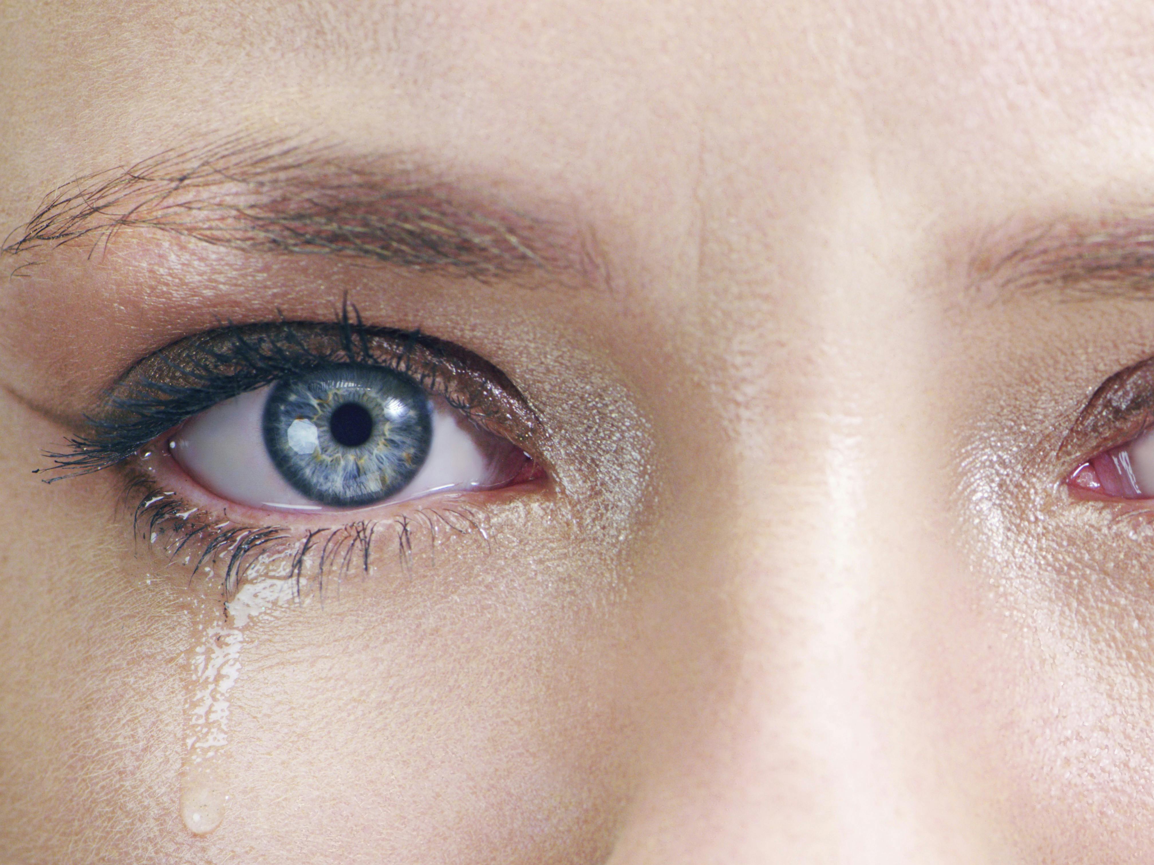 Nærbillede af ung kvinde med tårer i øjnene.