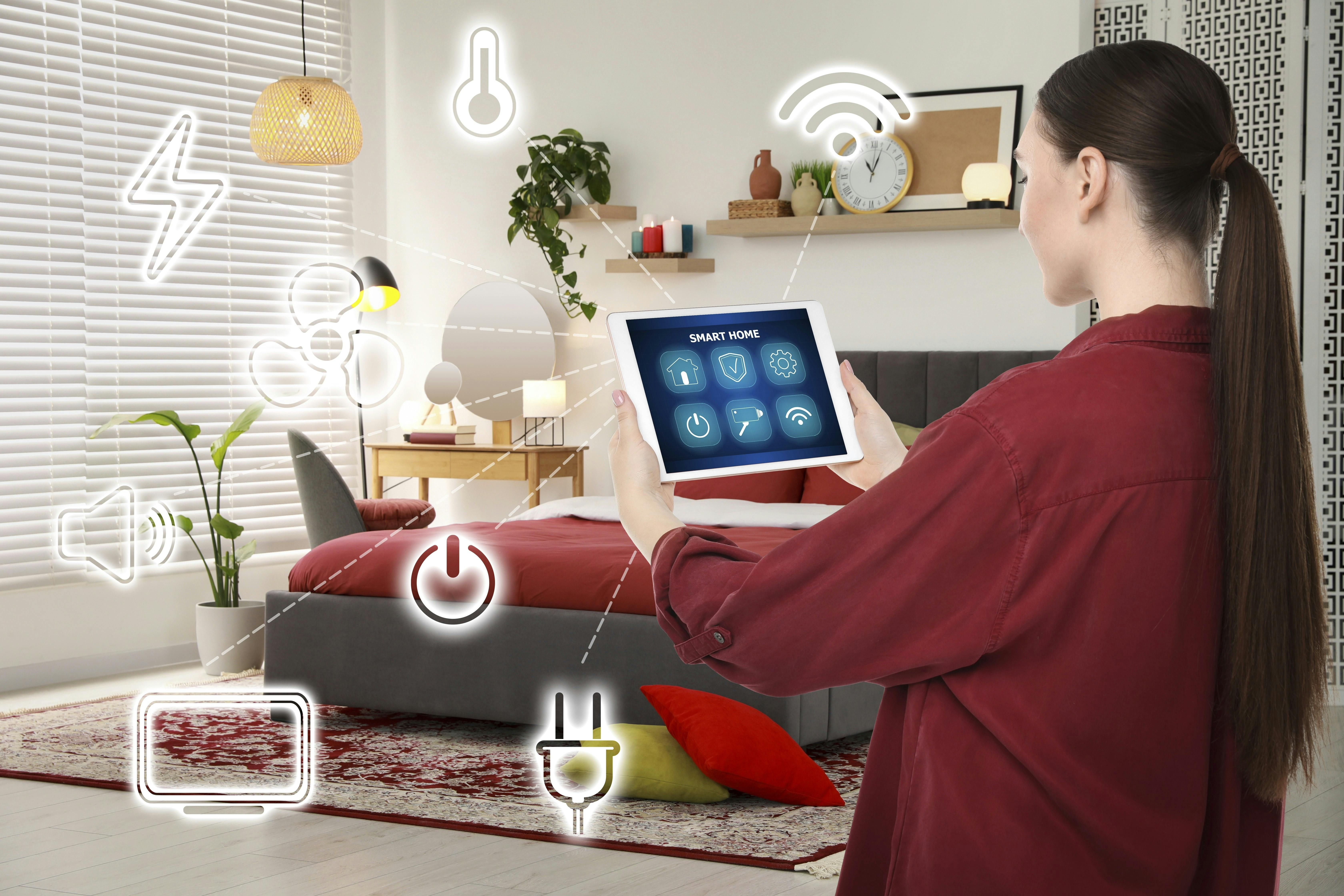 Woman using smart home control system via application on tablet indoors. Different icons connected with device