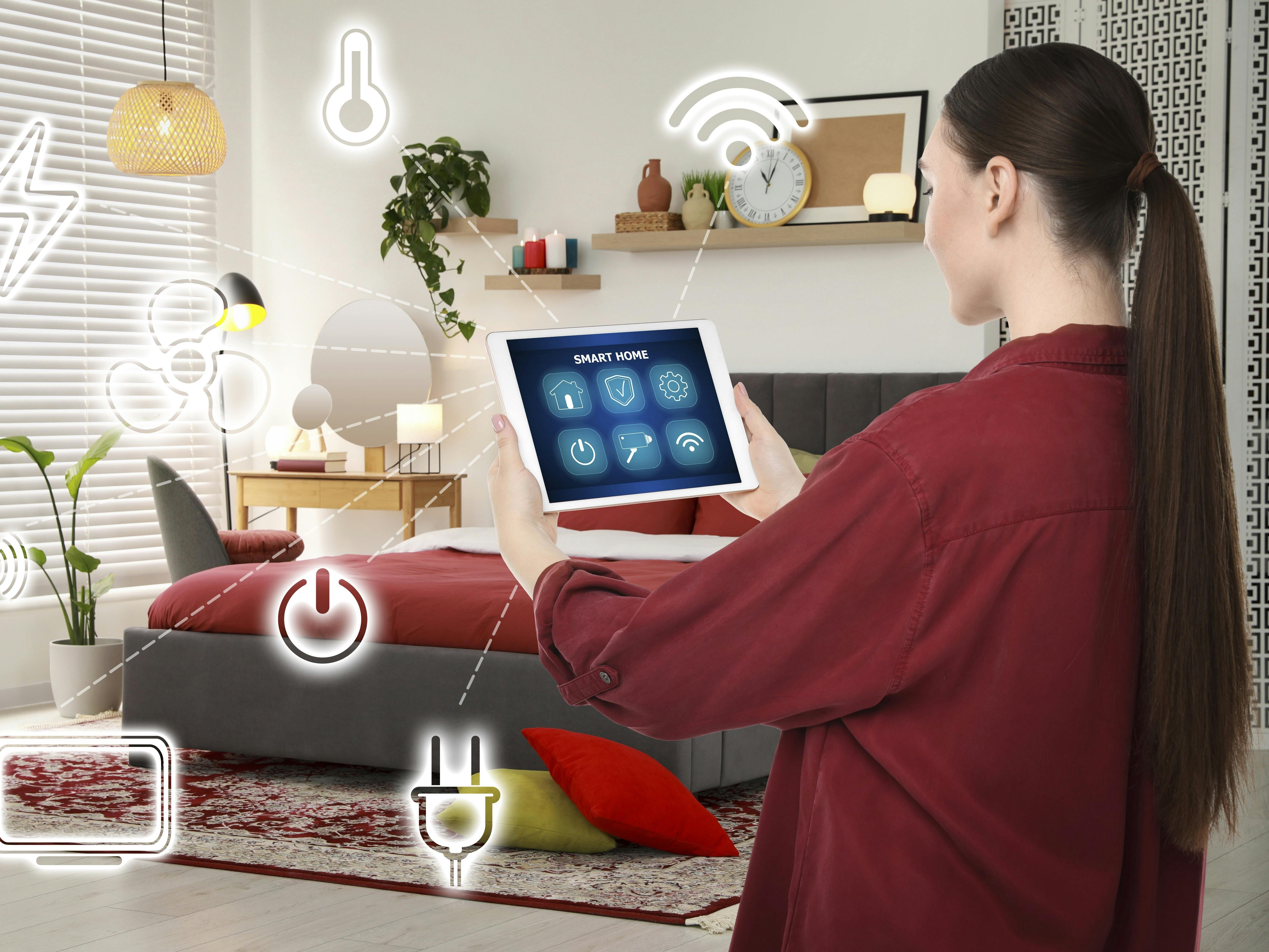 Woman using smart home control system via application on tablet indoors. Different icons connected with device