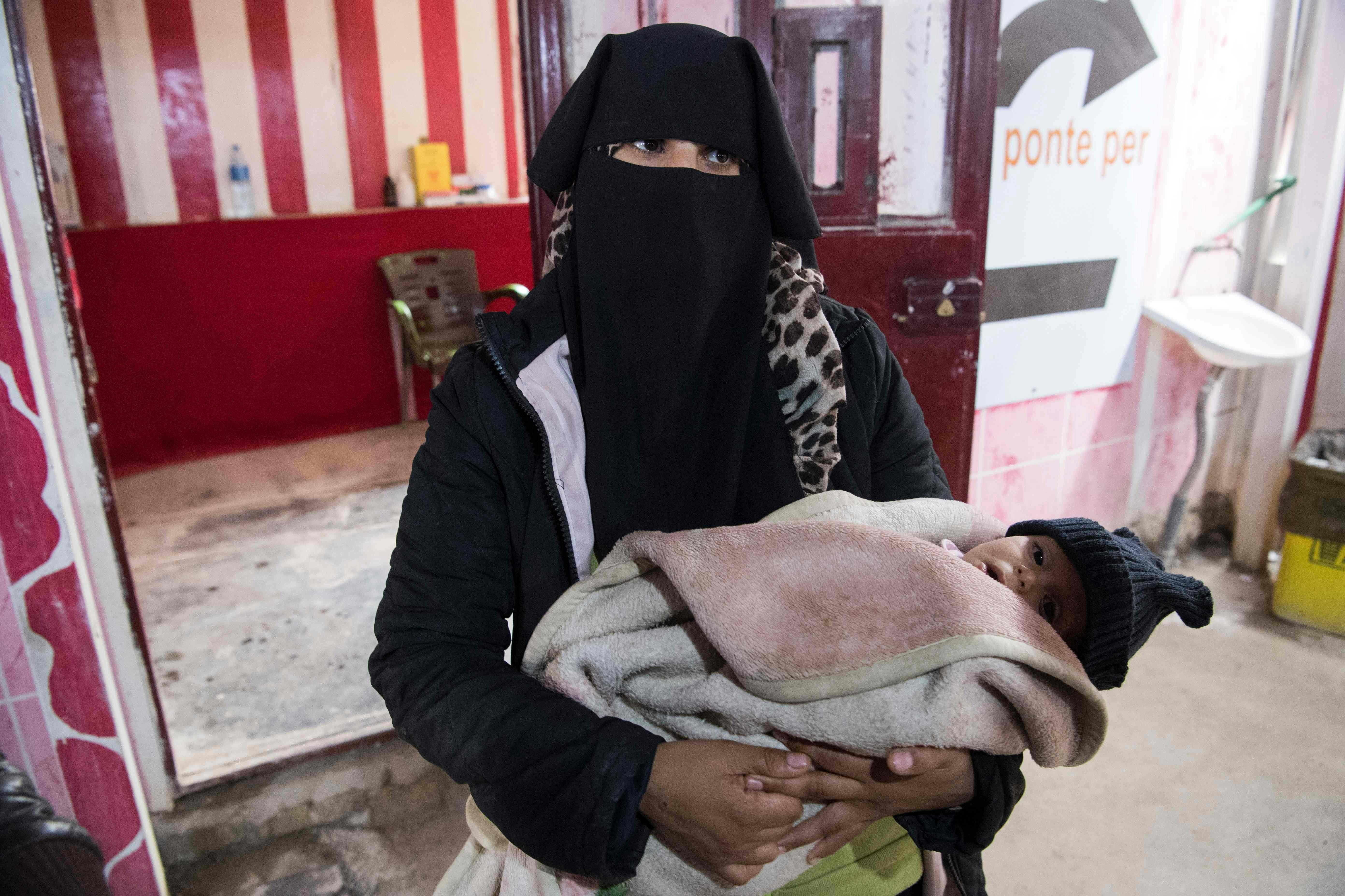 En syrisk kvinde holder et barn