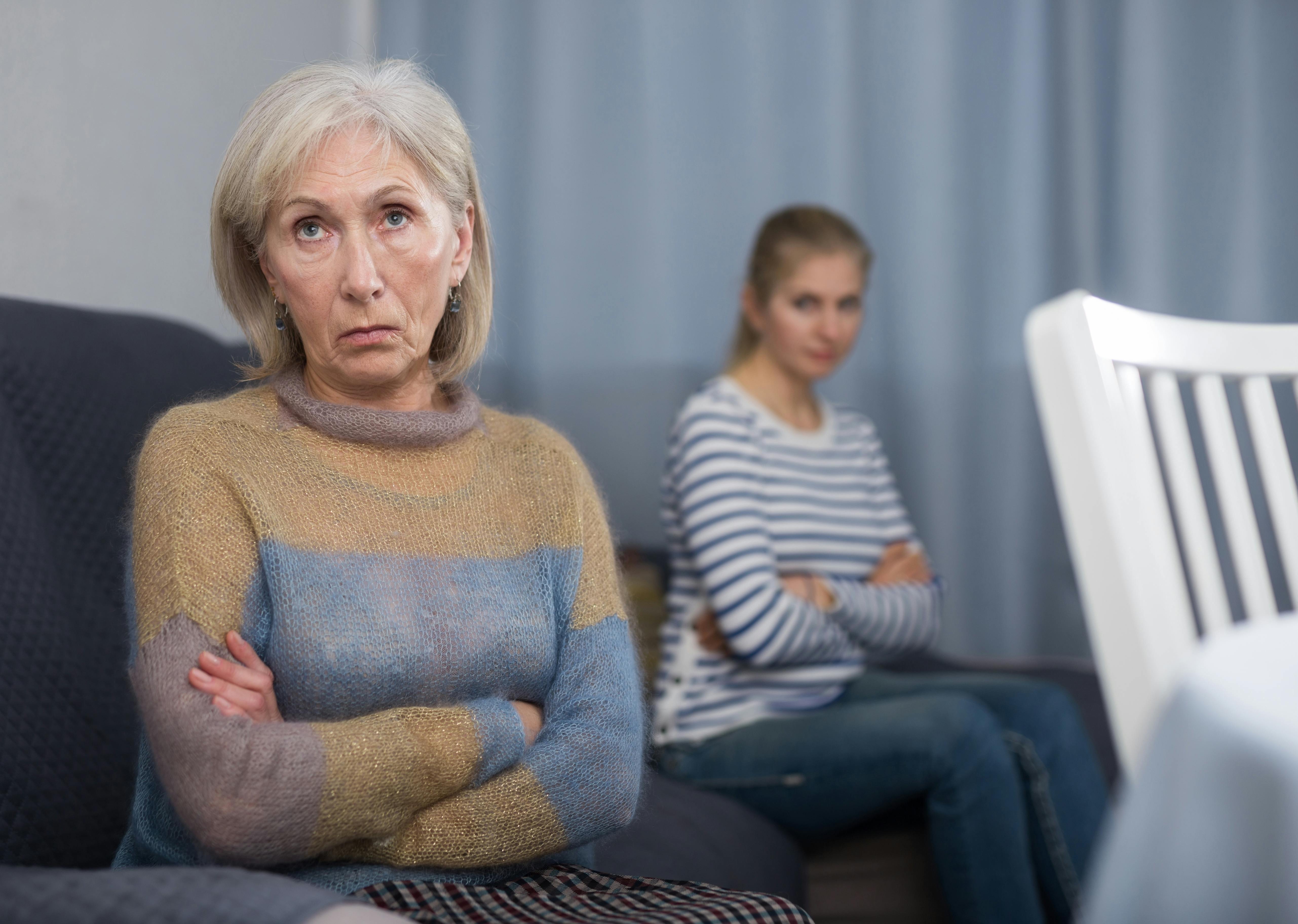 Ældre mor og hendes voksne datter skuler vredt til hinanden.