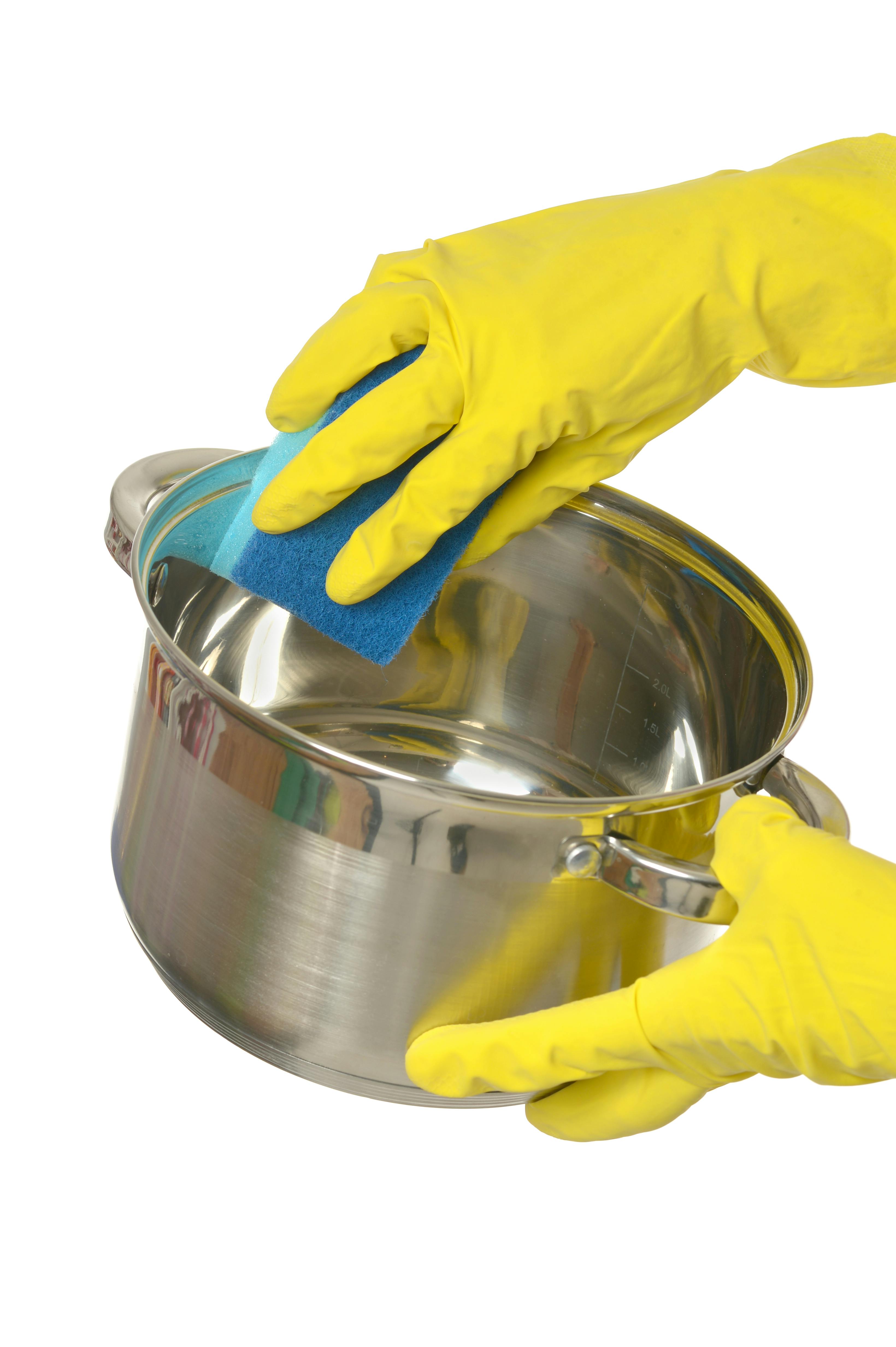 Close up female hands in rubber gloves washing pot