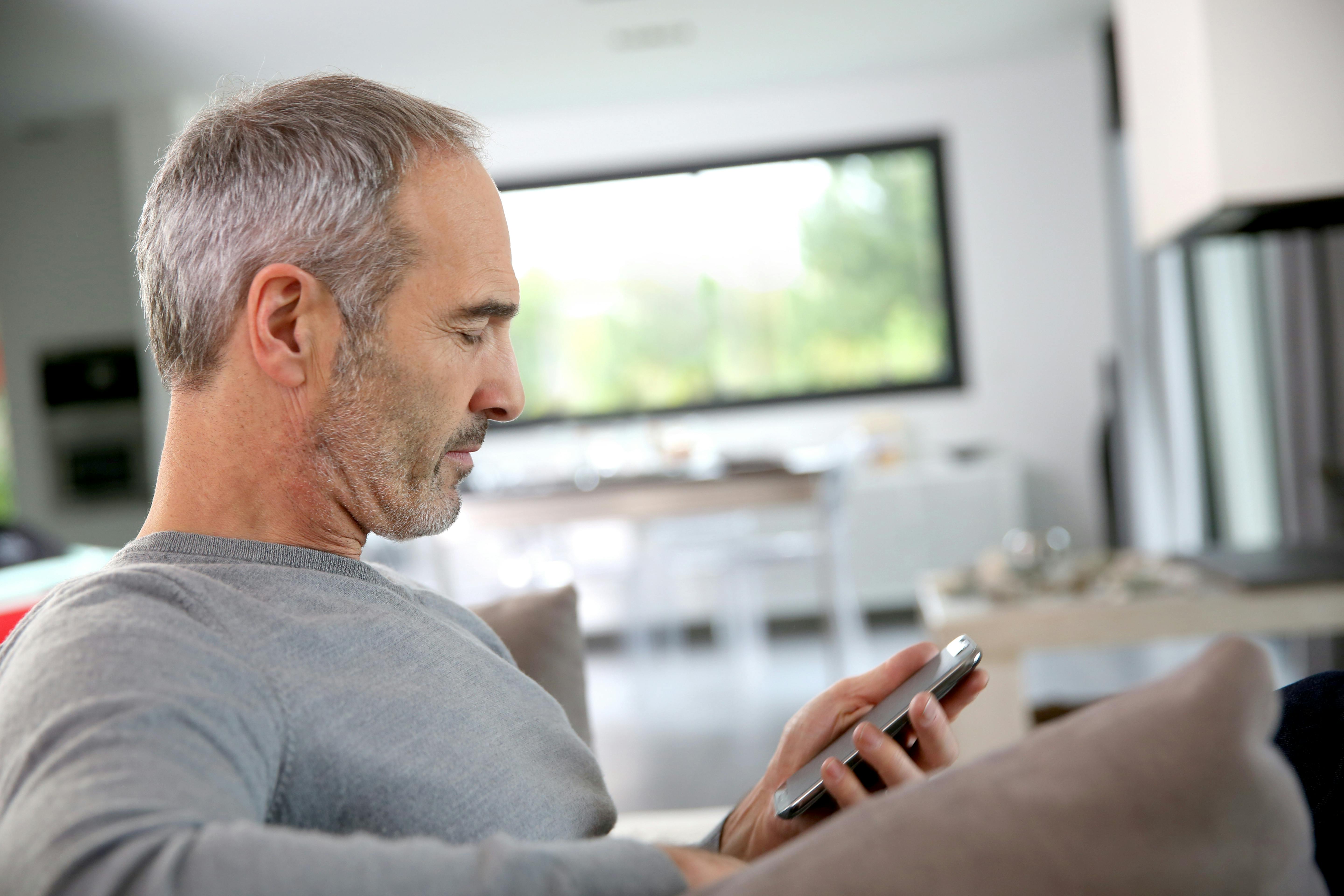 moden mand kigger på mobiltelefon