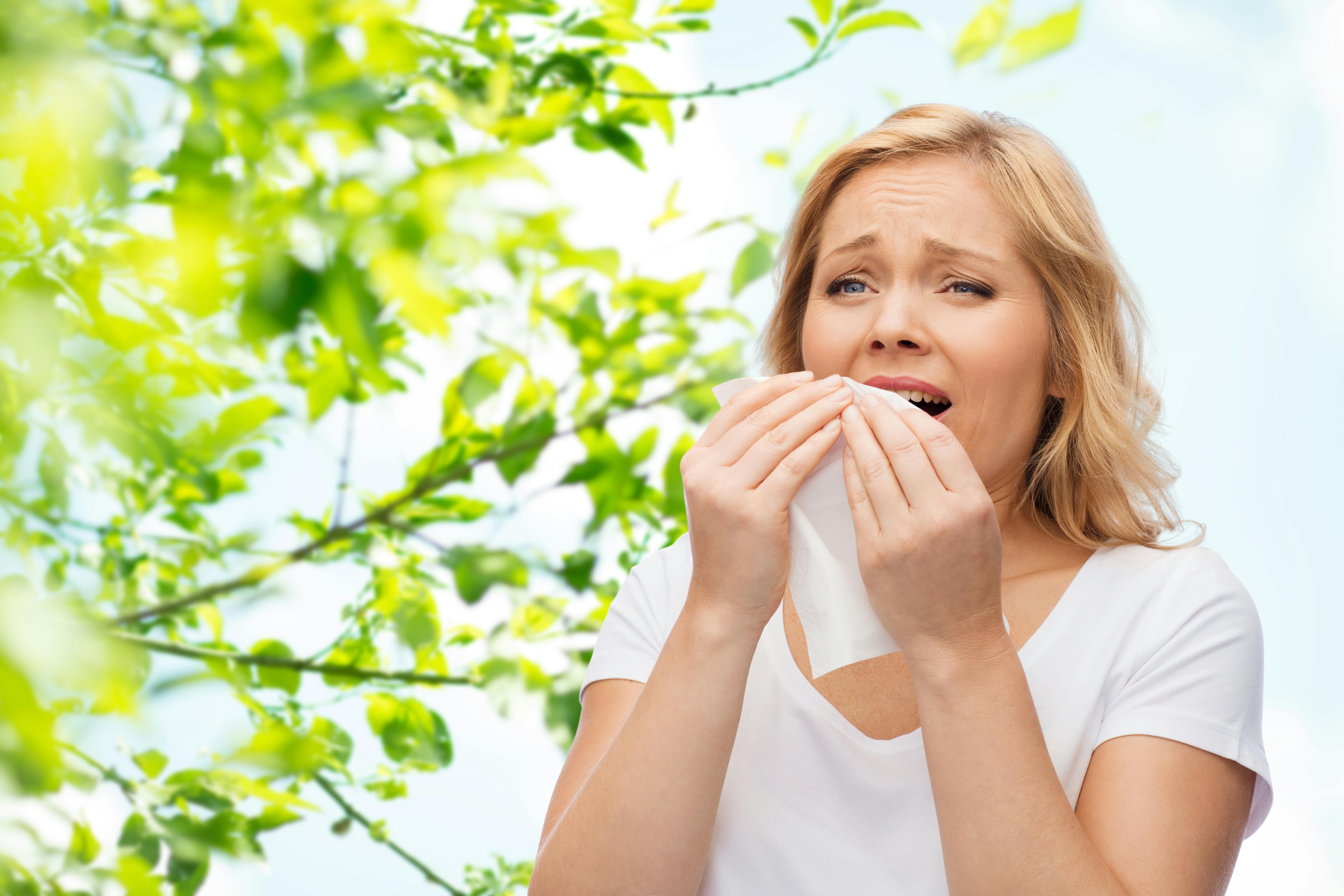 Allergisk kvinde nyser i naturen