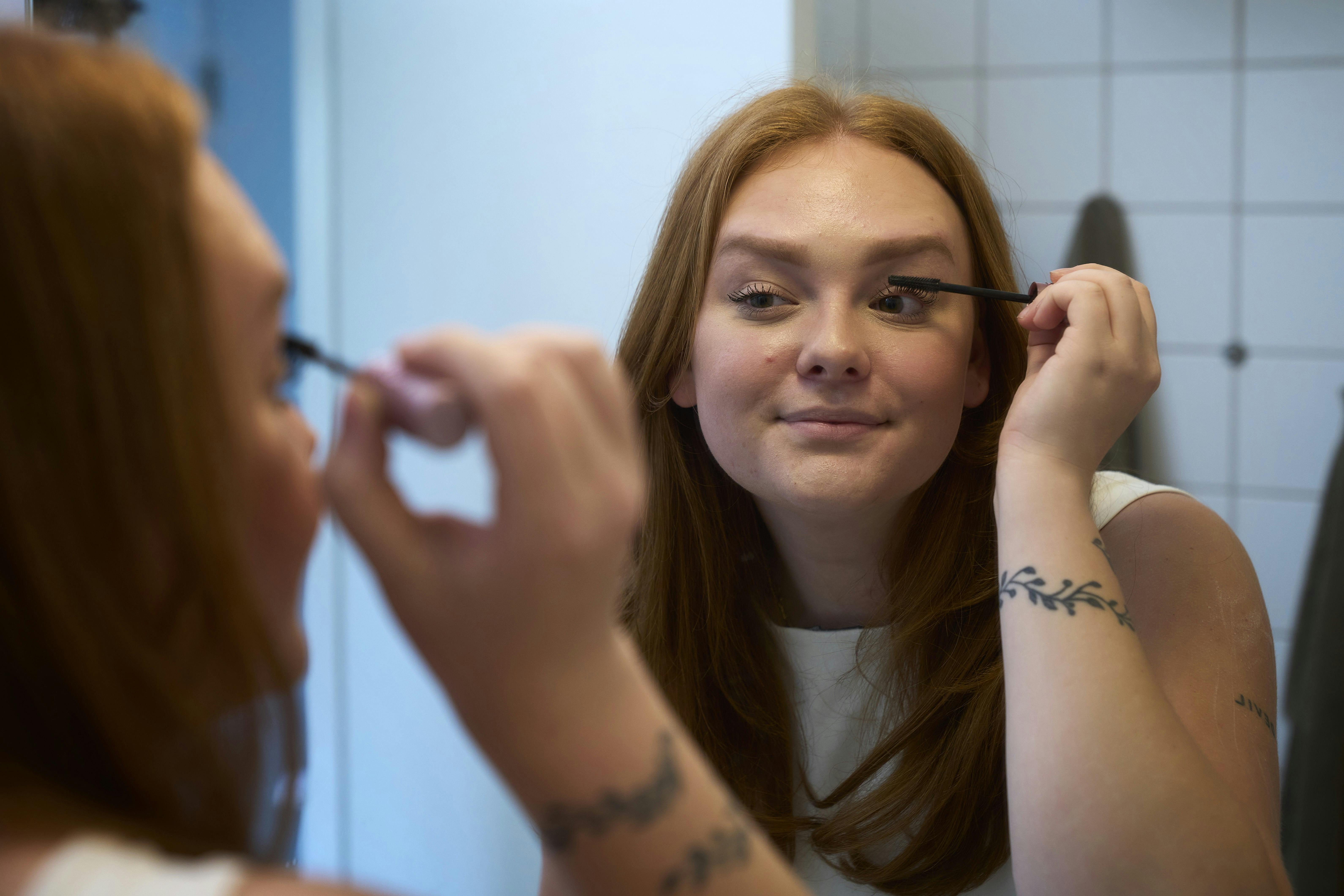 Nikita lægger makeup foran et spejl