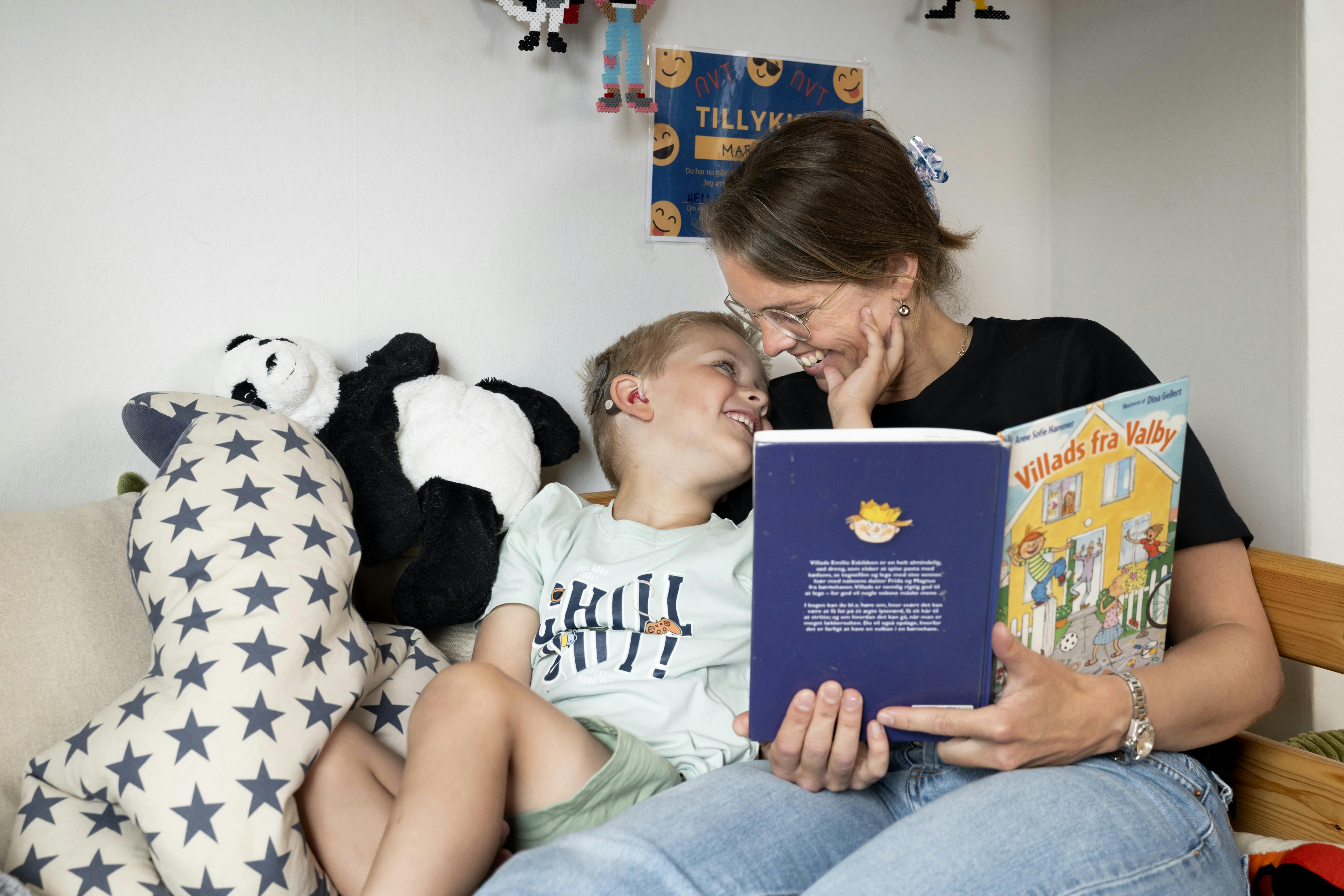 Moren Sofie sidder med en af sønnerne, og sidder og læser i en bog. 