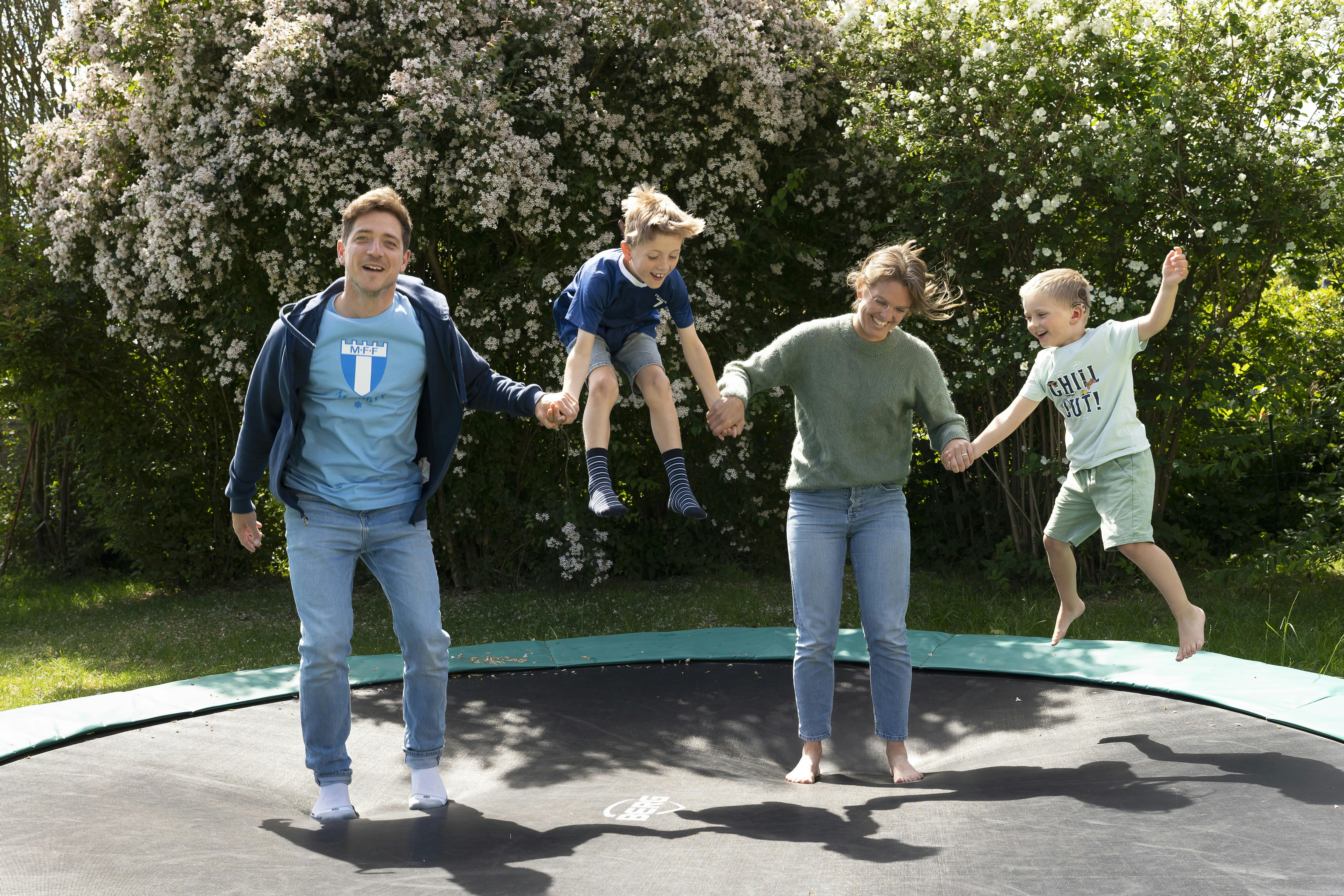 Hele familien der hopper på trampolin. 