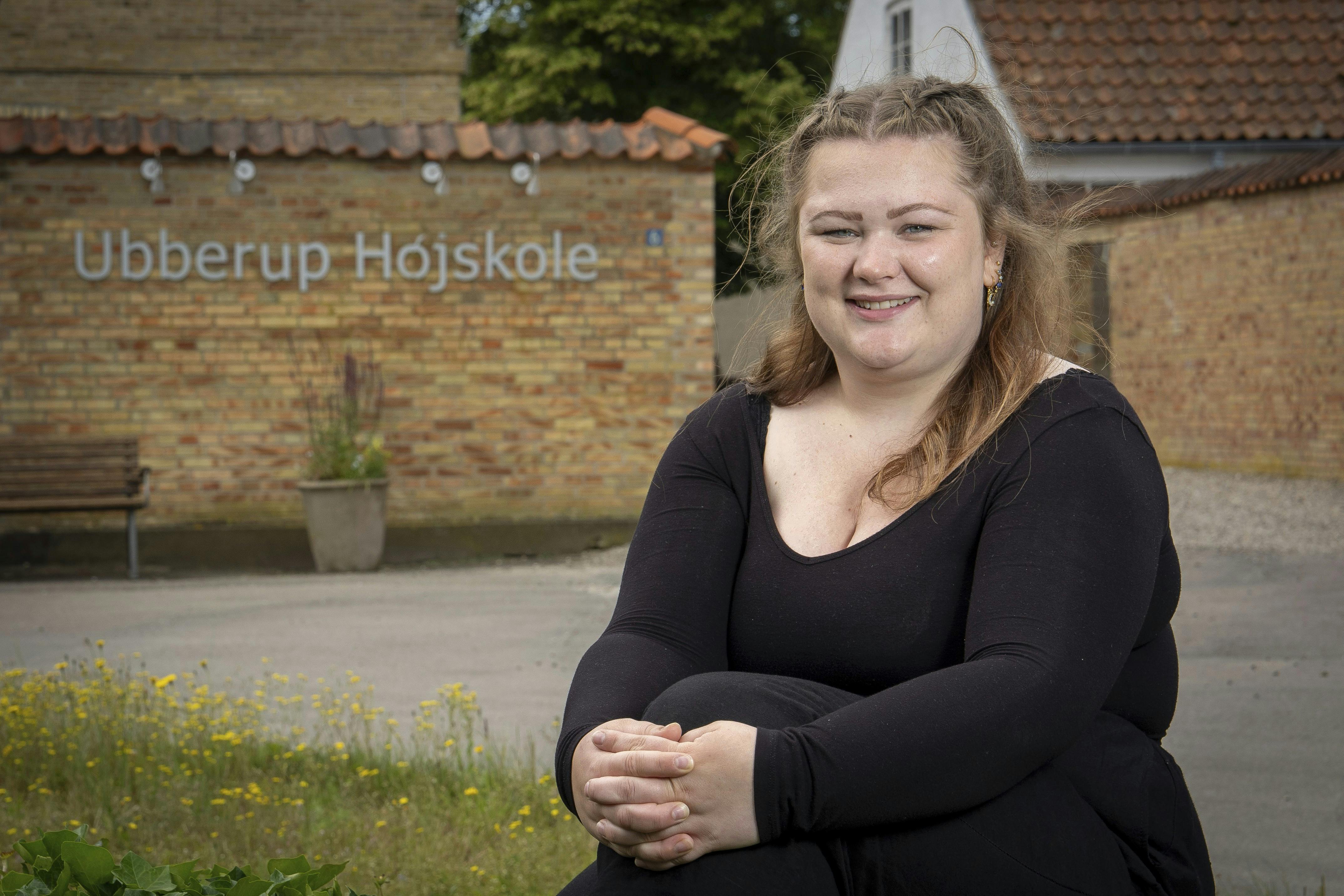 Pernille Høybye Jensen er på Ubberup Højskole. Her sidder hun på en stor sten foran højskolens bygning.