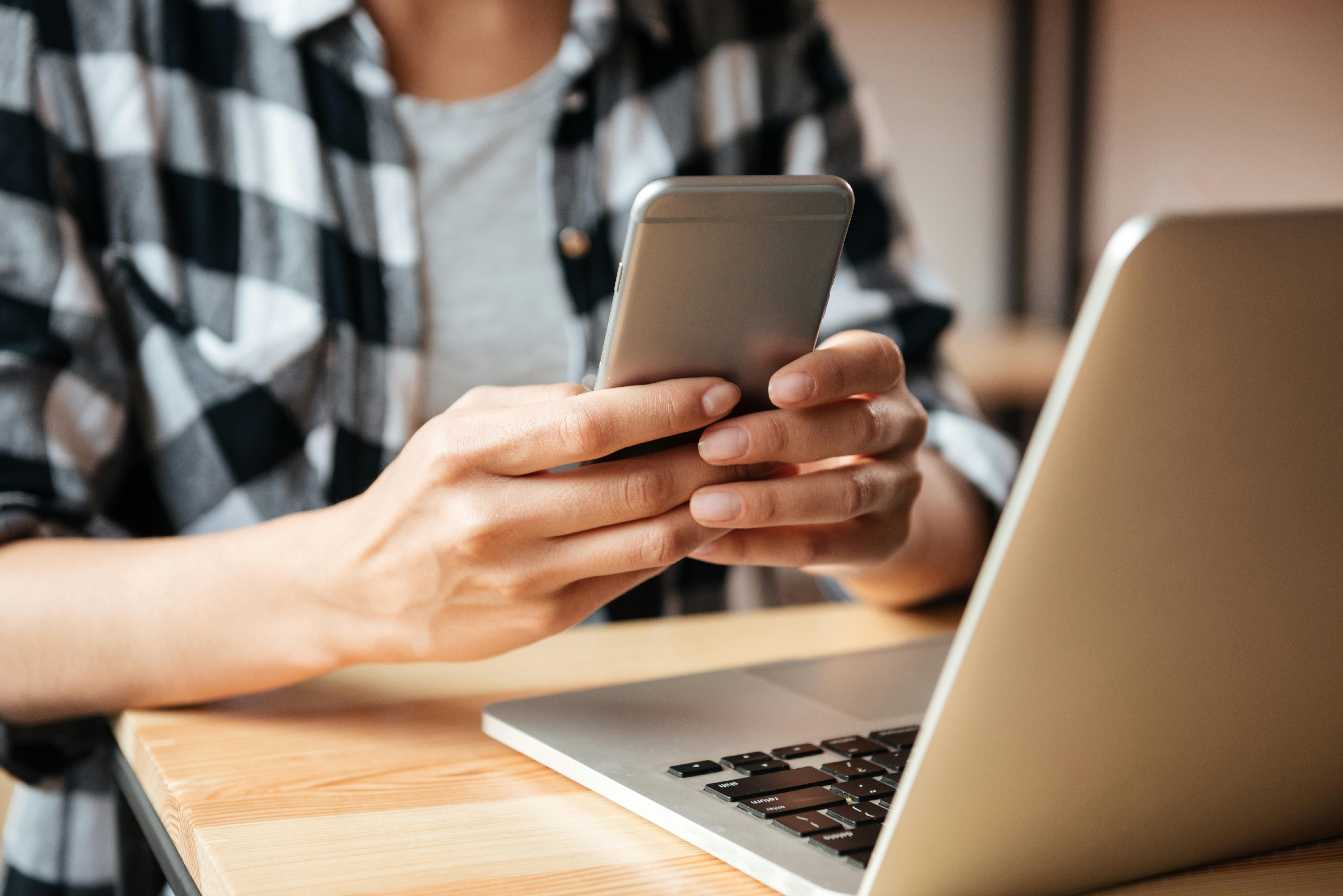 Kvinde med telefon og computer