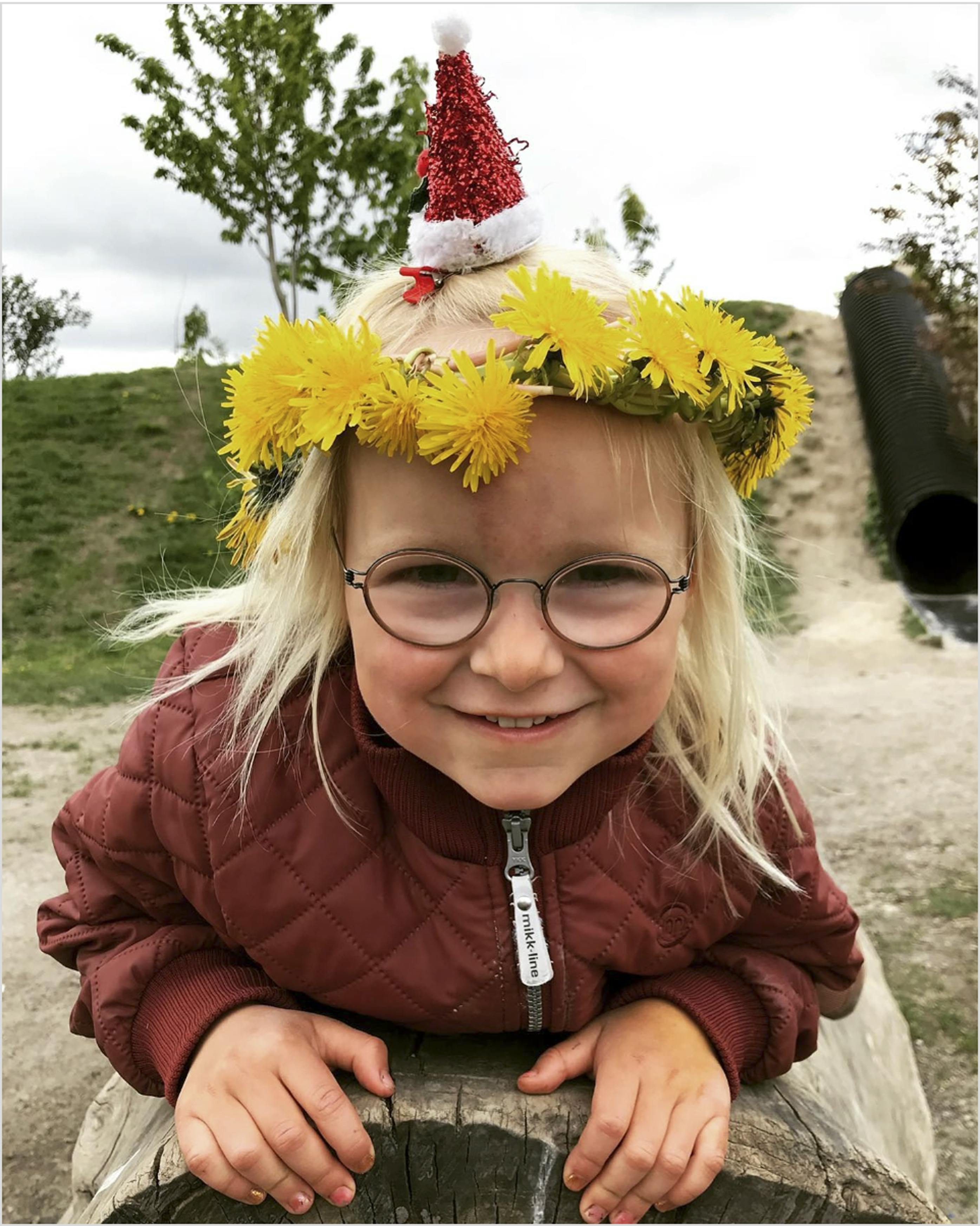 Karoline med en blomsterkrans på hovedet.