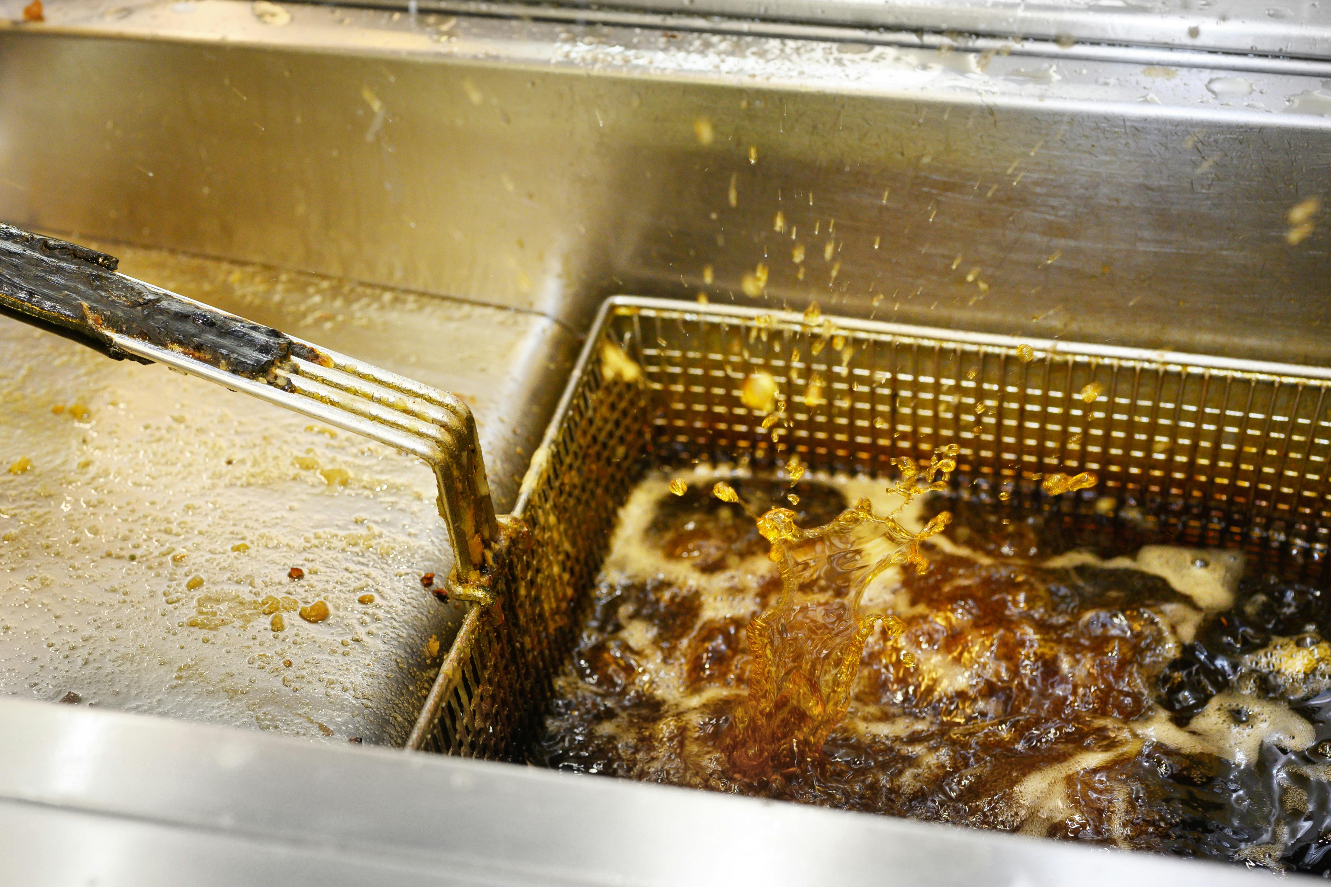 Greasy deep fryer with splashing boiling oil. High quality photo