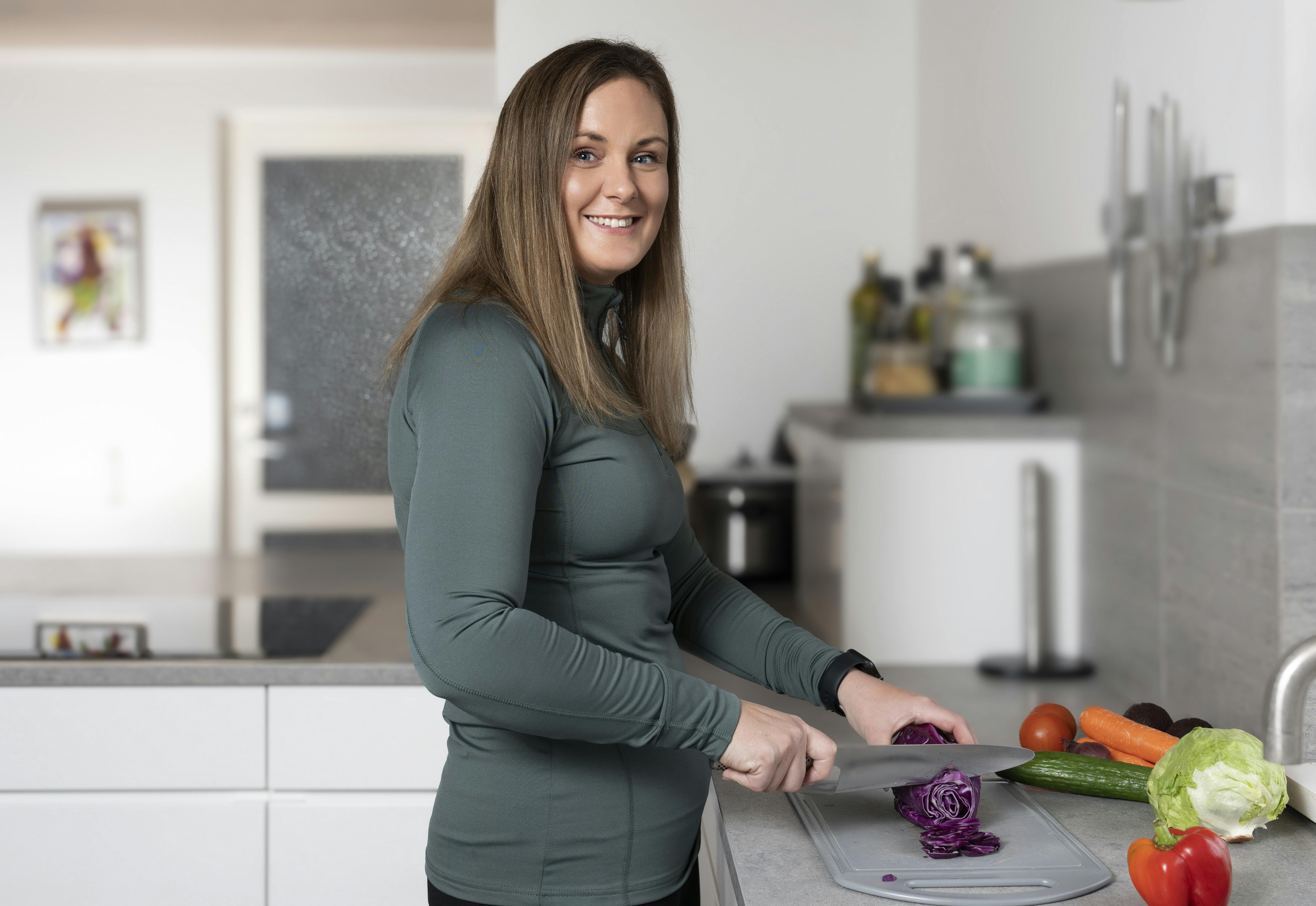 Sandra Mai Schirakow står i sit køkken og snitter grøntsager til dagens menu.