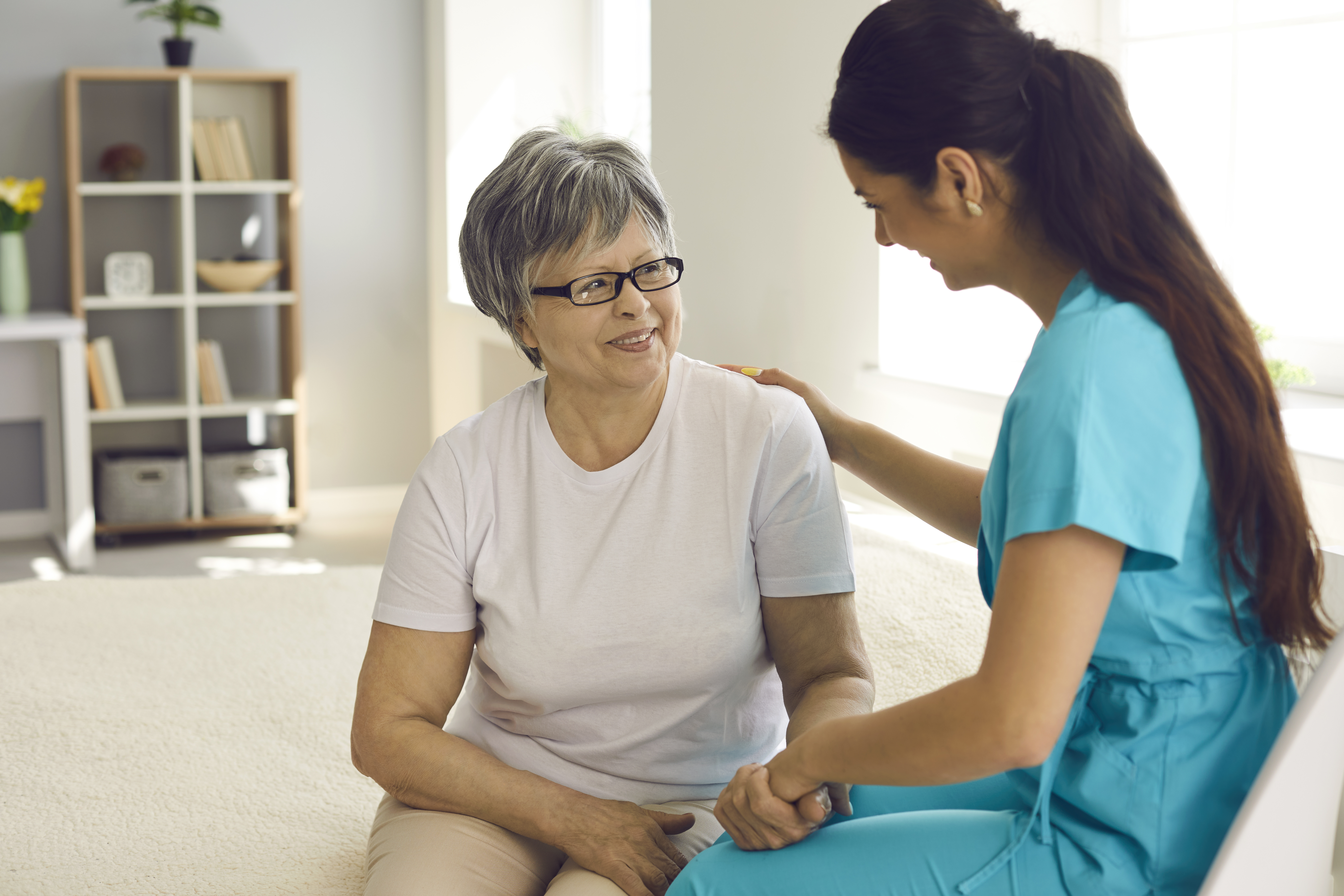 Venlig sygeplejerske med ældre kvindelig patient